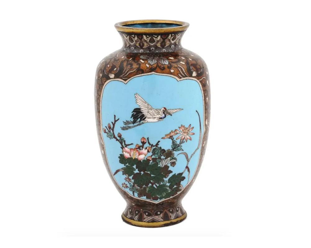 Vase japonais de haute qualité en forme d'amphore, émaillé sur laiton. Le vase est orné de médaillons en émail polychrome représentant une grue et des fleurs épanouies, ainsi qu'un paysage du soir avec un croissant sur fond turquoise entouré de