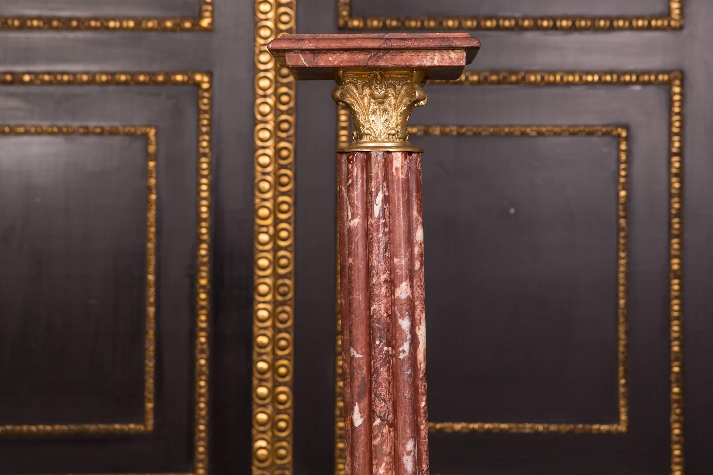 Bordeaux red, real marble with gray-white grain. Square plinth with balustrade shaped column base with decorated bronze capitelle. Exceptionally good quality. Wide, stepped square top plate.