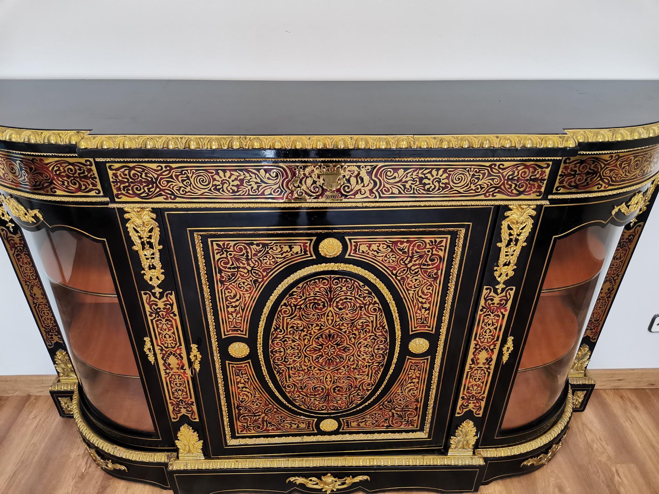 High quality sideboard opening with three blackened wood doors, Boulle style tortoiseshell and brass marquetry, beautiful ornamentation of gilded bronzes. Napoleon III period. In a perfect state. 
Very good condition. 
Dimensions: 1.88m long,
