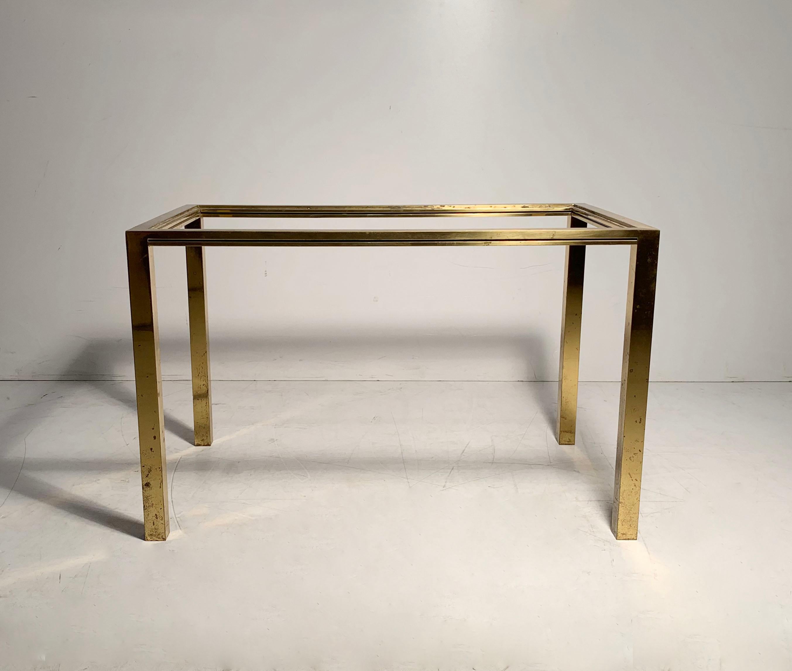 High quality vintage petite brass coffee table attributed to Jansen. Table has wear overall to the finish. A heavy weight piece that is structurally Sound. The brass section under the top frame are solid bar. In the manner of Milo Baughman