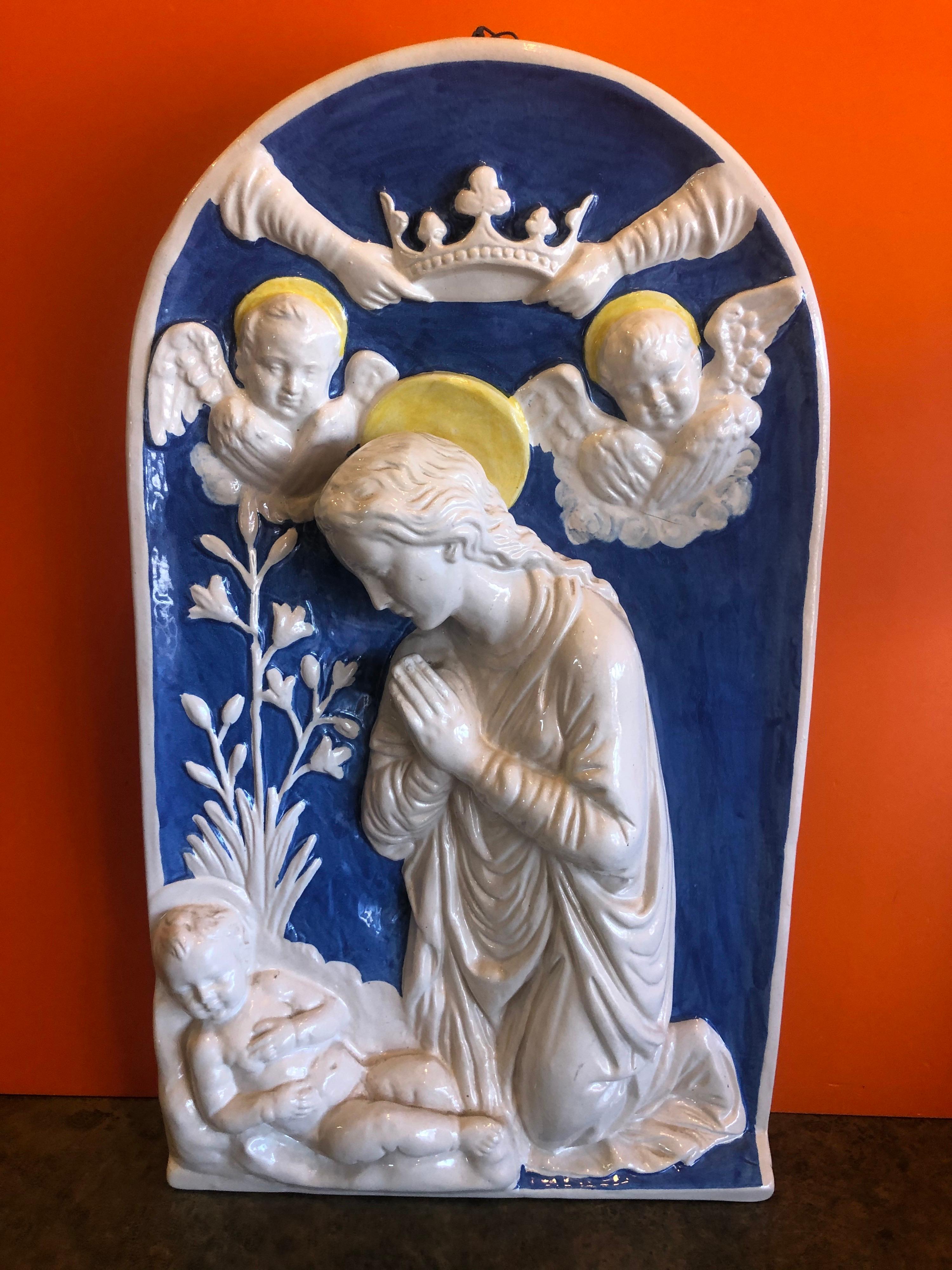 Rectangular high relief polychrome glazed pottery Madonna plaque by Della Robbia of Italy, circa 1980s. The neoclassical work depicts the Virgin Mary with Baby Jesus and two angels in a classic Della Robbia blue and white glaze. The piece is signed