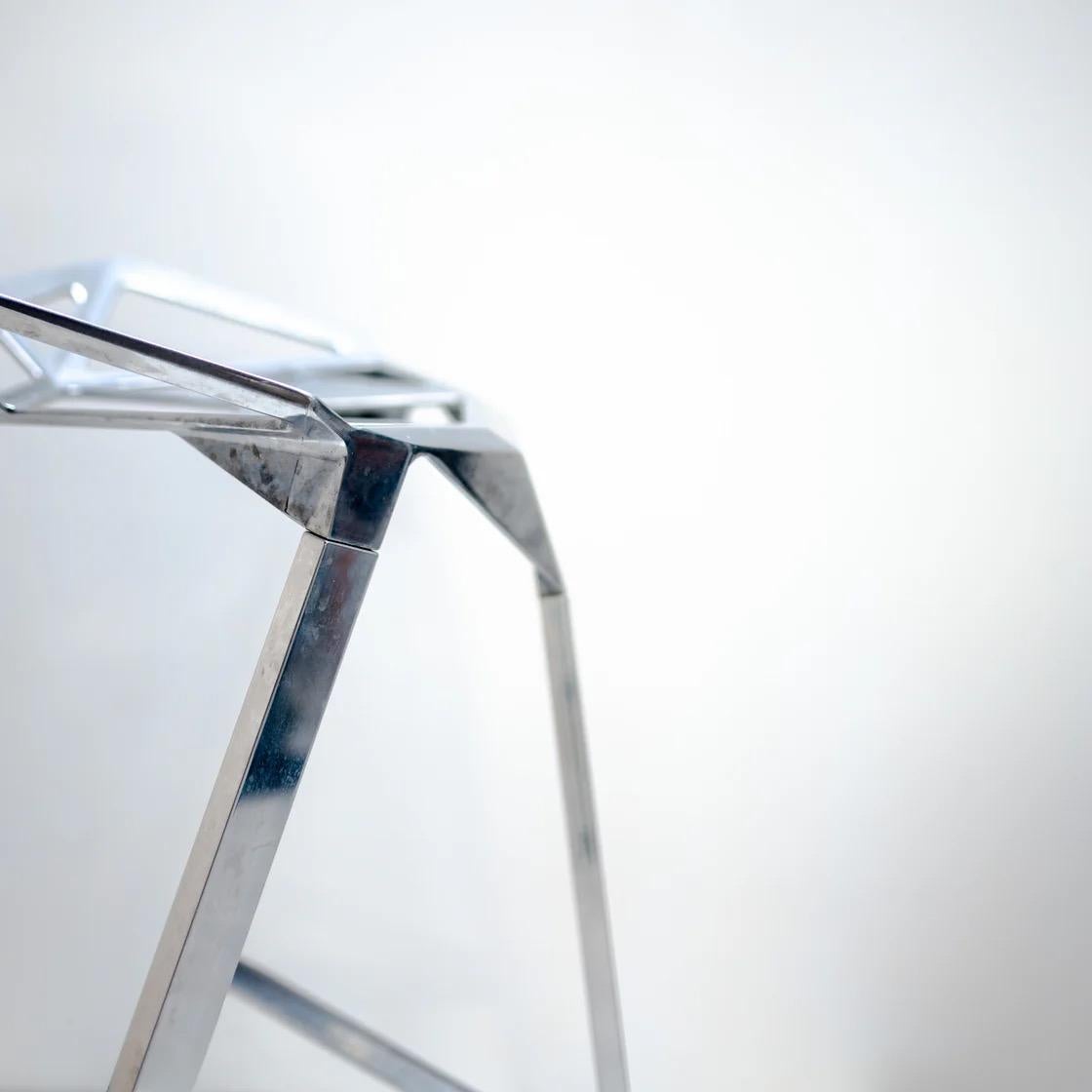 Crafted entirely from polished metal, its angular silhouette captures light and shadow in unexpected ways, giving the piece a sculptural quality beyond its functional use. 
A design that transforms a simple stool into an architectural statement for