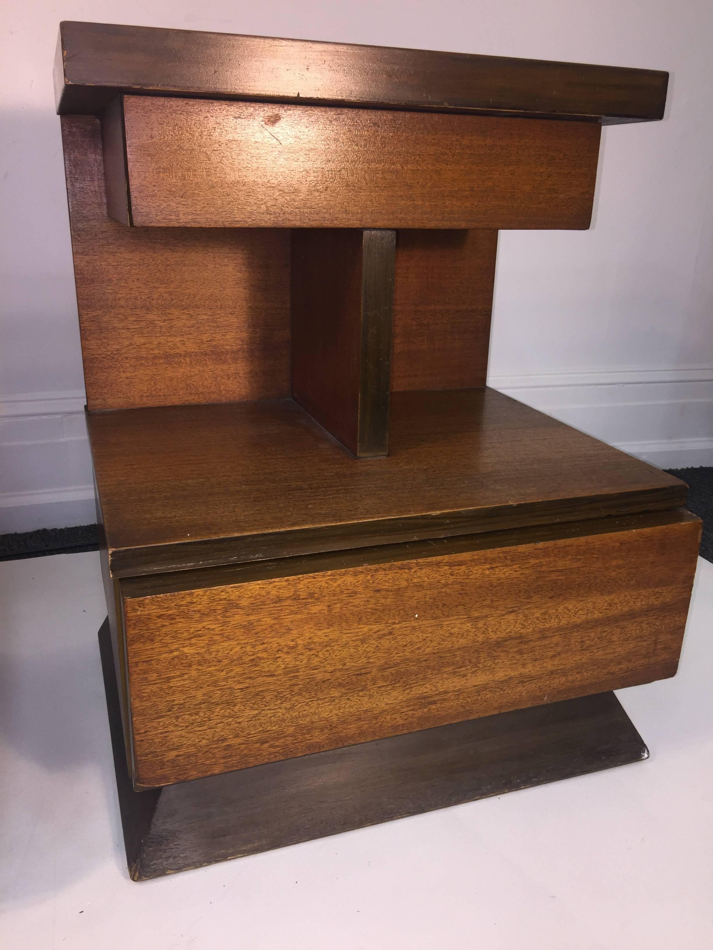 Modernist pair of American modern nightstands with two drawers in ebony and walnut striated wood designed in an angular modern design. In original midcentury unrestored condition. If wanting these perfect refinishing is recommended.
 