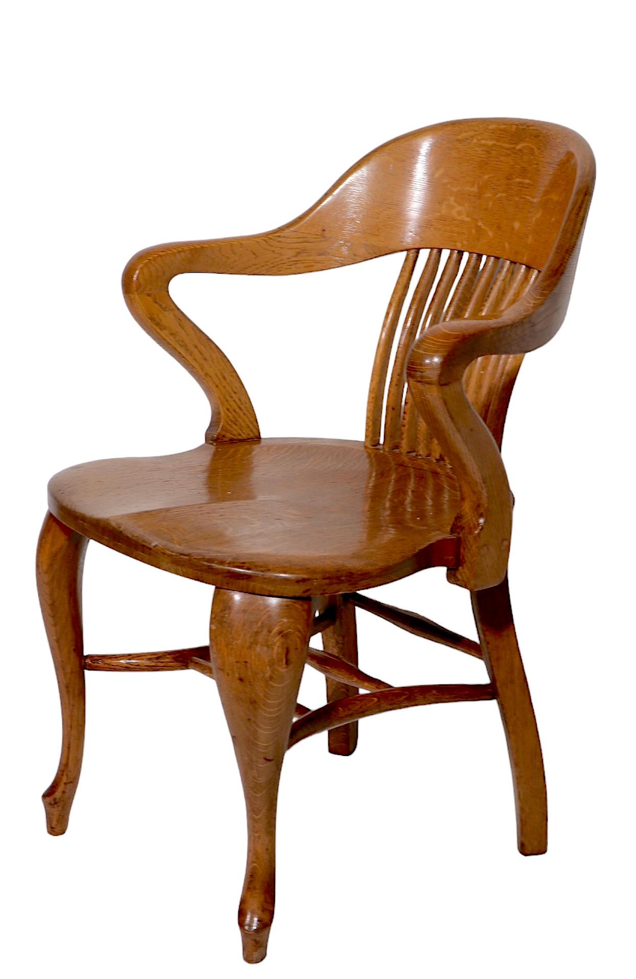 Exceptional Bank of England, Jury style arm chair in solid oak. The chair features a curvaceous continuous arm and  back rest, on curved cabriole style legs. This example is very solid, and sturdy, is has been nicely refinished and is in clean,