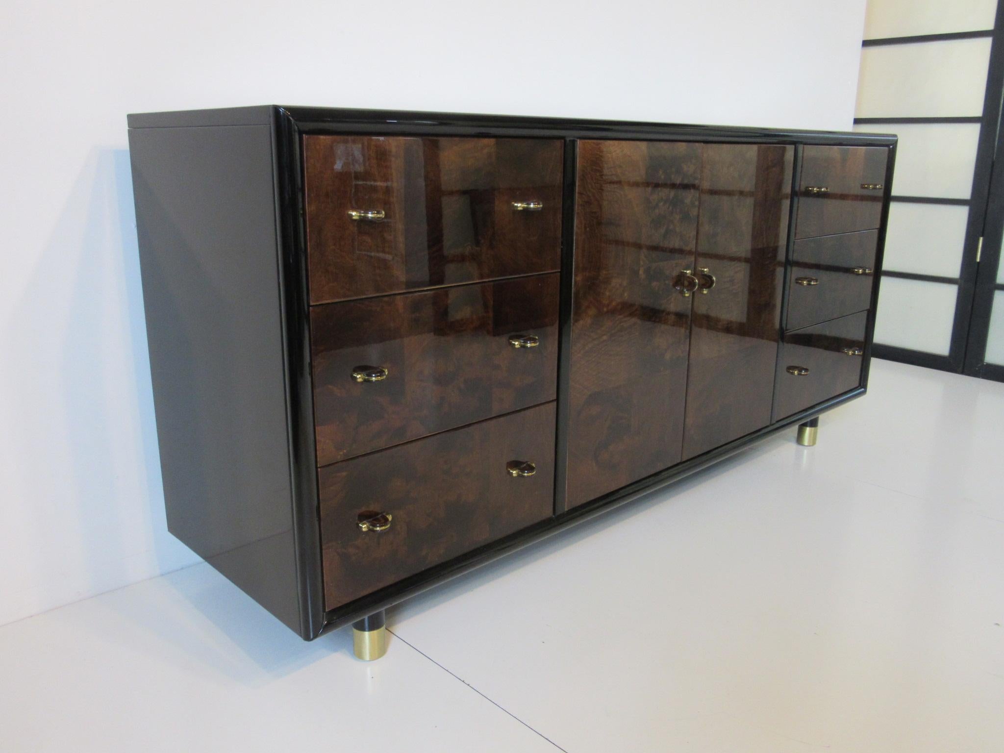 A high gloss black lacquer chest / cabinet with rich burl wood drawer fronts and doors, three drawers to each side and double doors with one adjustable shelve. This well-crafted and quality
piece has detailed matching wood pulls with brass to each