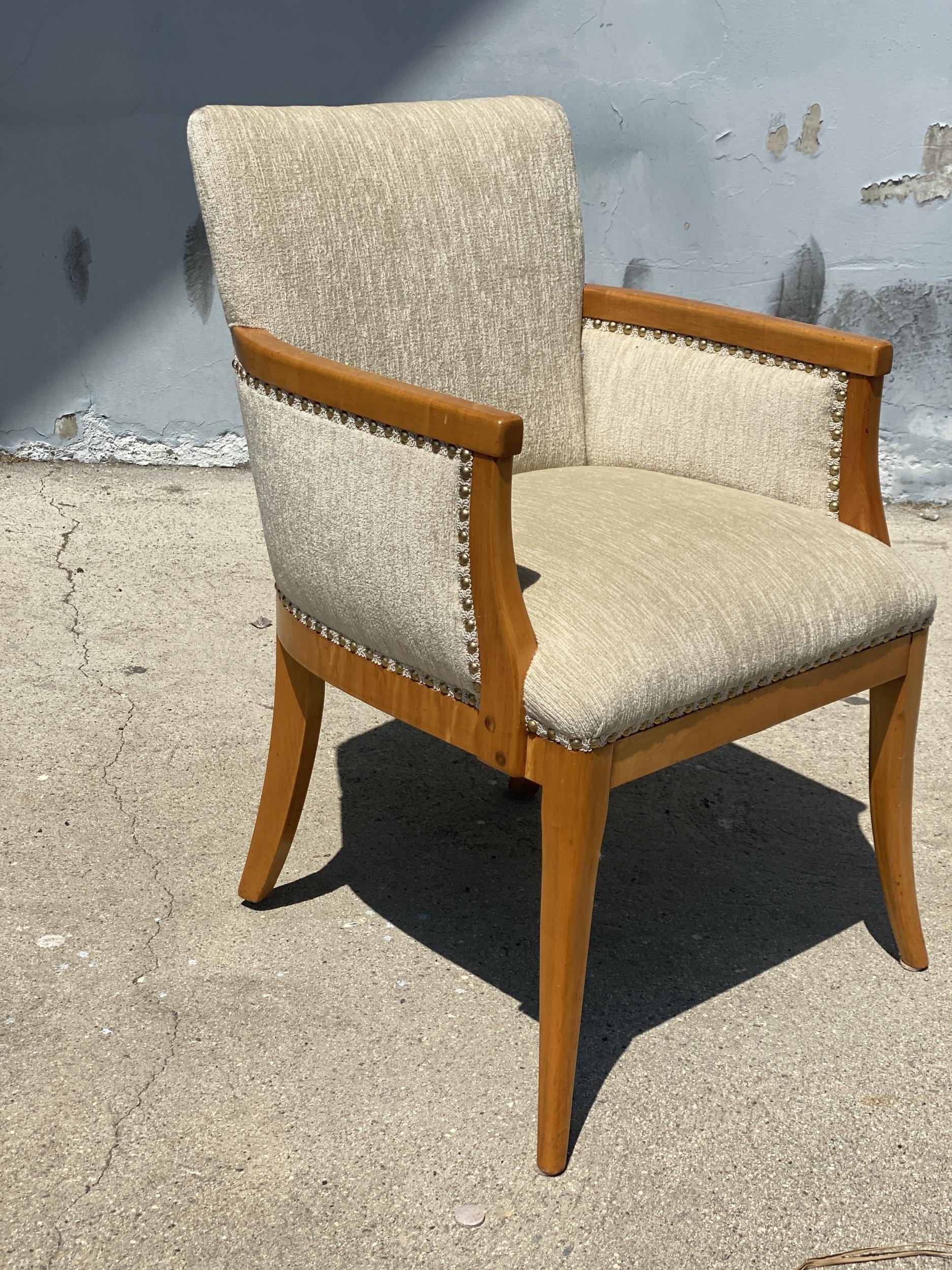 Circa 1950 modern Heywood Wakefield reading chair with stylished pouf ottoman. The chair featuring a beautiful wood border with nail-back decorative edge and tapered legs. The ottoman features a large overstuffed top and stylized tapered legs.
