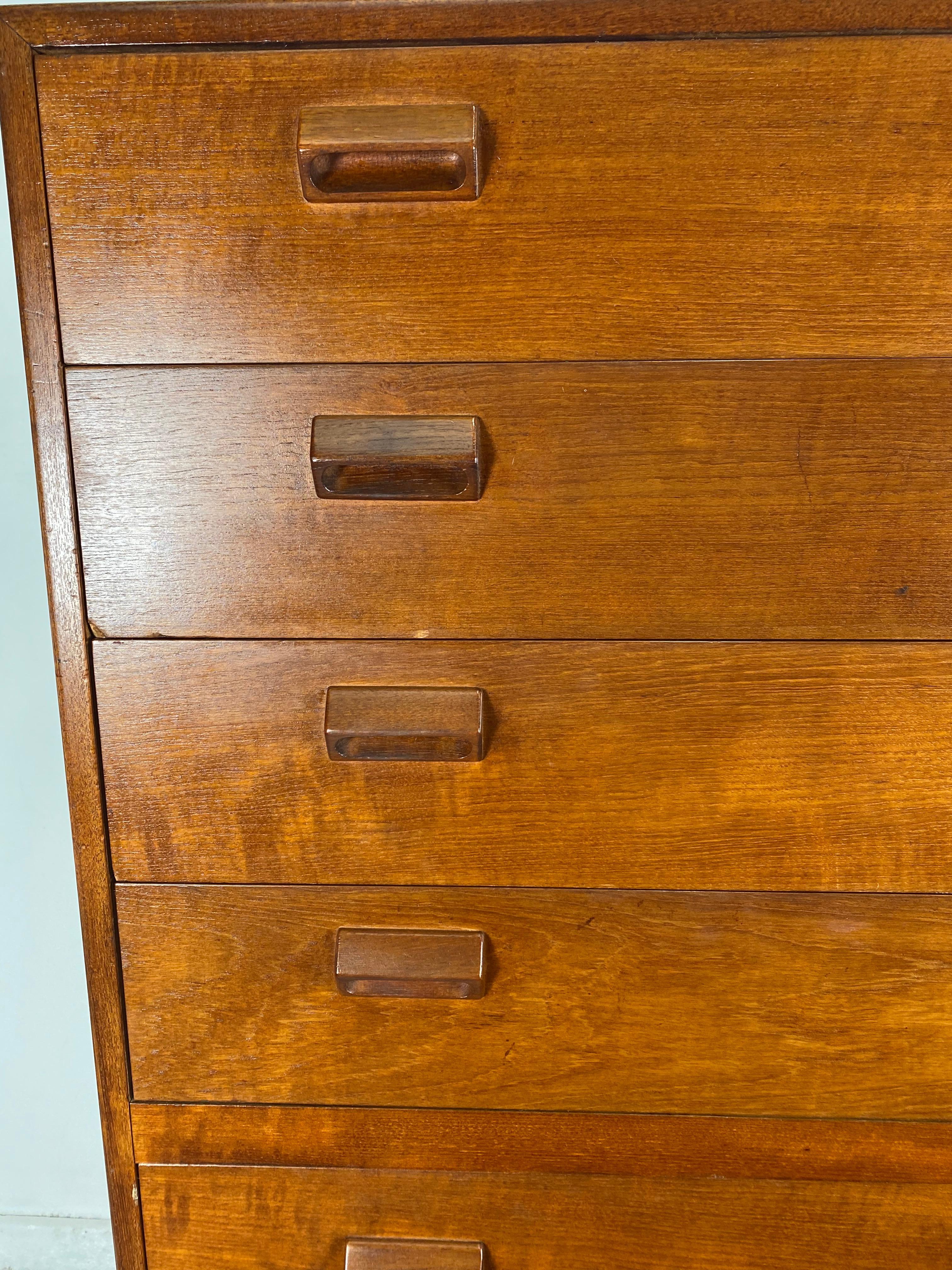 Stunning Teak  High dresser by Borge Mogensen for Neils Vodder, Denmark 1950s. A tall seven (7) drawer dresser or chest of drawers designed by Borge Mogensen. Dresser is constructed of solid teak wood with integrated wood handles on an oak base with