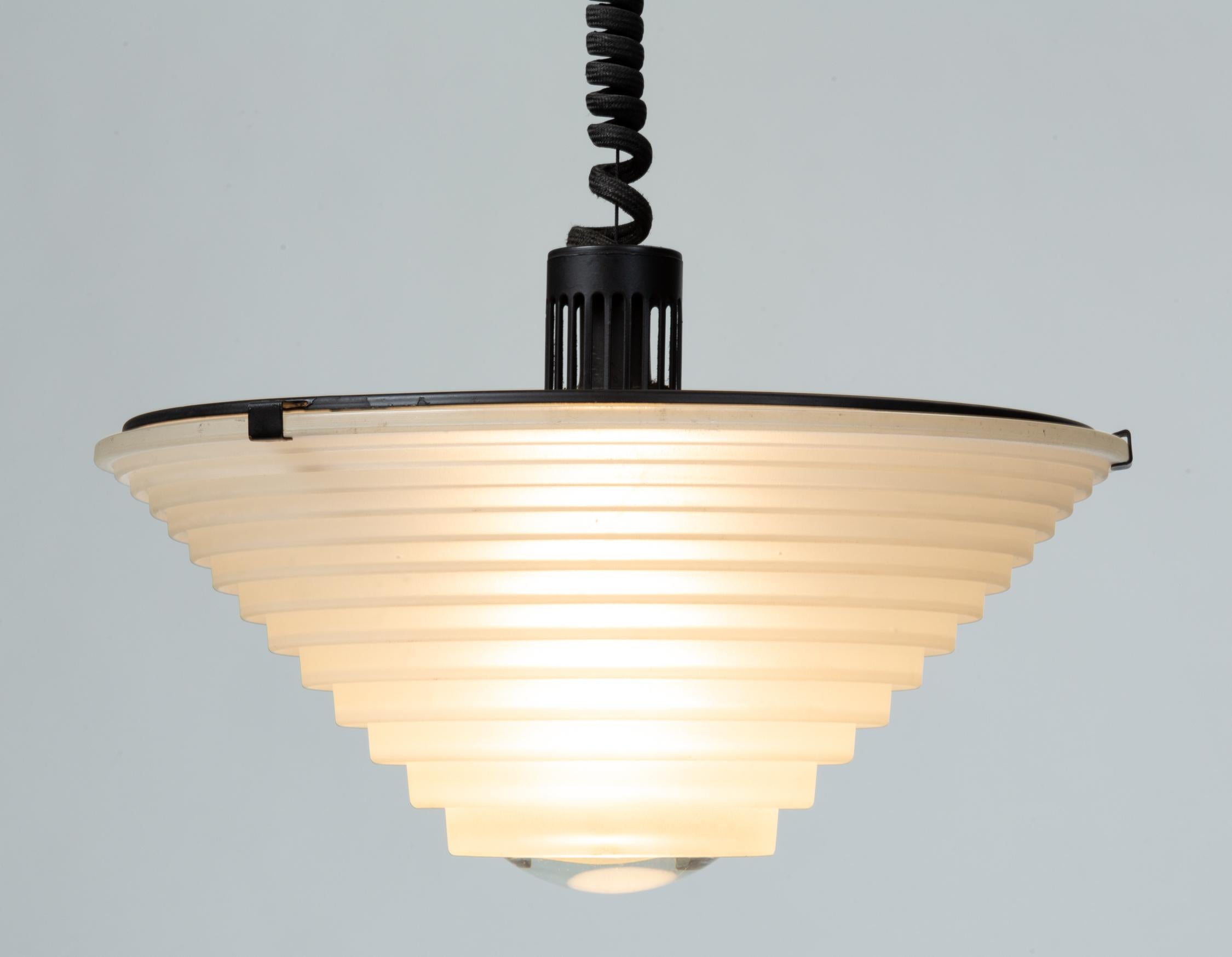 A consummate example of late 1970s “high tech” or “matte black” design that folded together rich stylistic flourishes with utilitarian or industrial materials, the “Egina 38” pendant lamp by Angelo Mangiarotti for Artemide features a stepped glass
