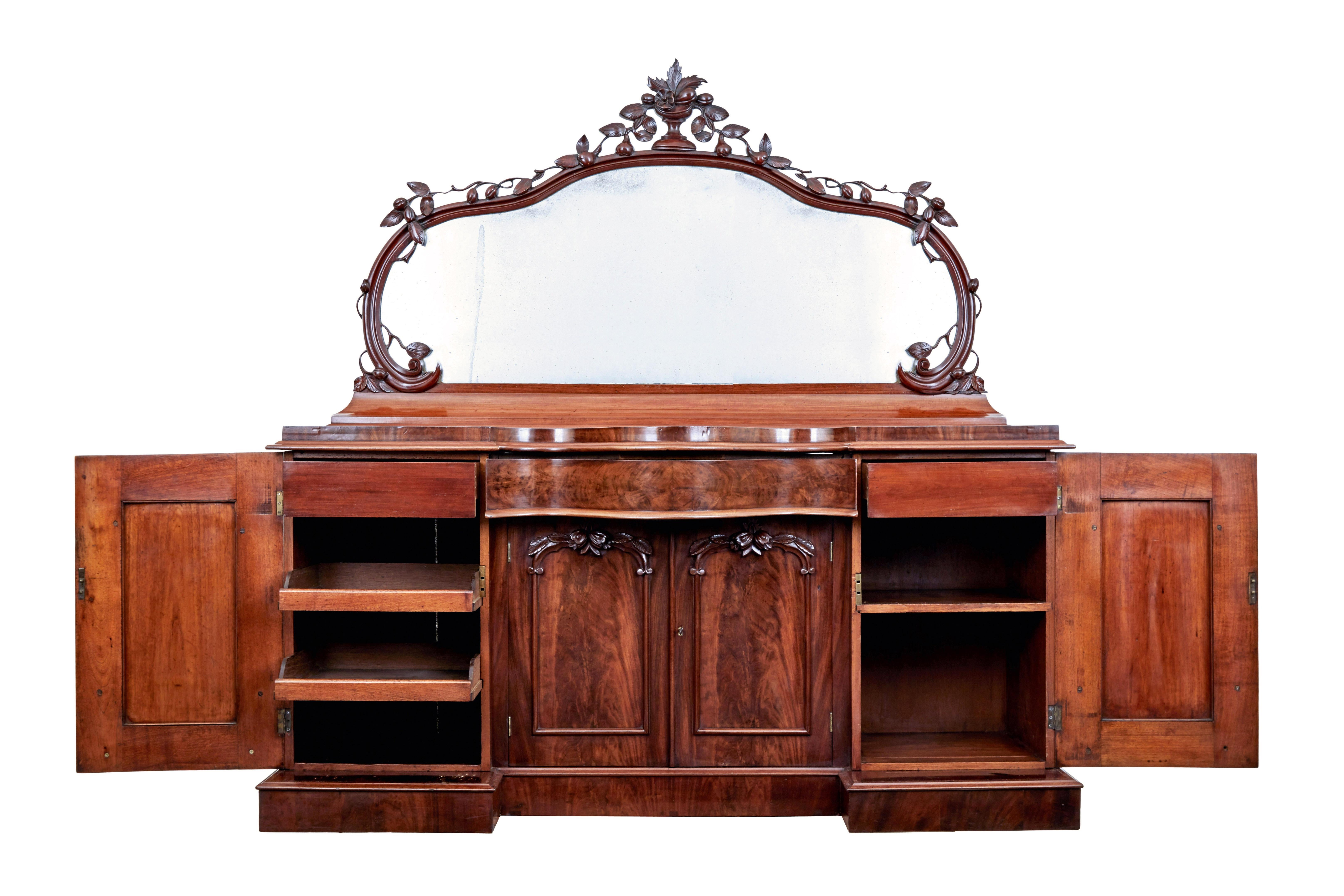 Buffet à miroir en acajou flammé de forme victorienne vers 1860.

Buffet de qualité en deux parties. Miroir de forme avec plaque d'origine, coupe sculptée en haut avec des feuilles et des fruits qui descendent jusqu'à la base du miroir.

Base avec
