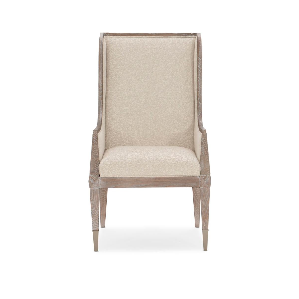 Highback Ash Modern dining armchair, a handsome addition at any table, the armchair elevates every dining experience. Its timeless silhouette is brought to life in a casually elegant Ash Driftwood finish and complemented with a finely tailored, luxe