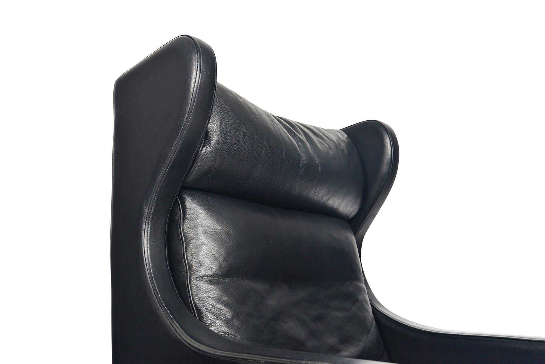 This stately highback leather lounge chairs was crafted by Skipper Møbler. The wingback design holds three cushions upholstered in original pebbled black leather. The chair stands on a routed cherrywood base. In excellent original condition.

 