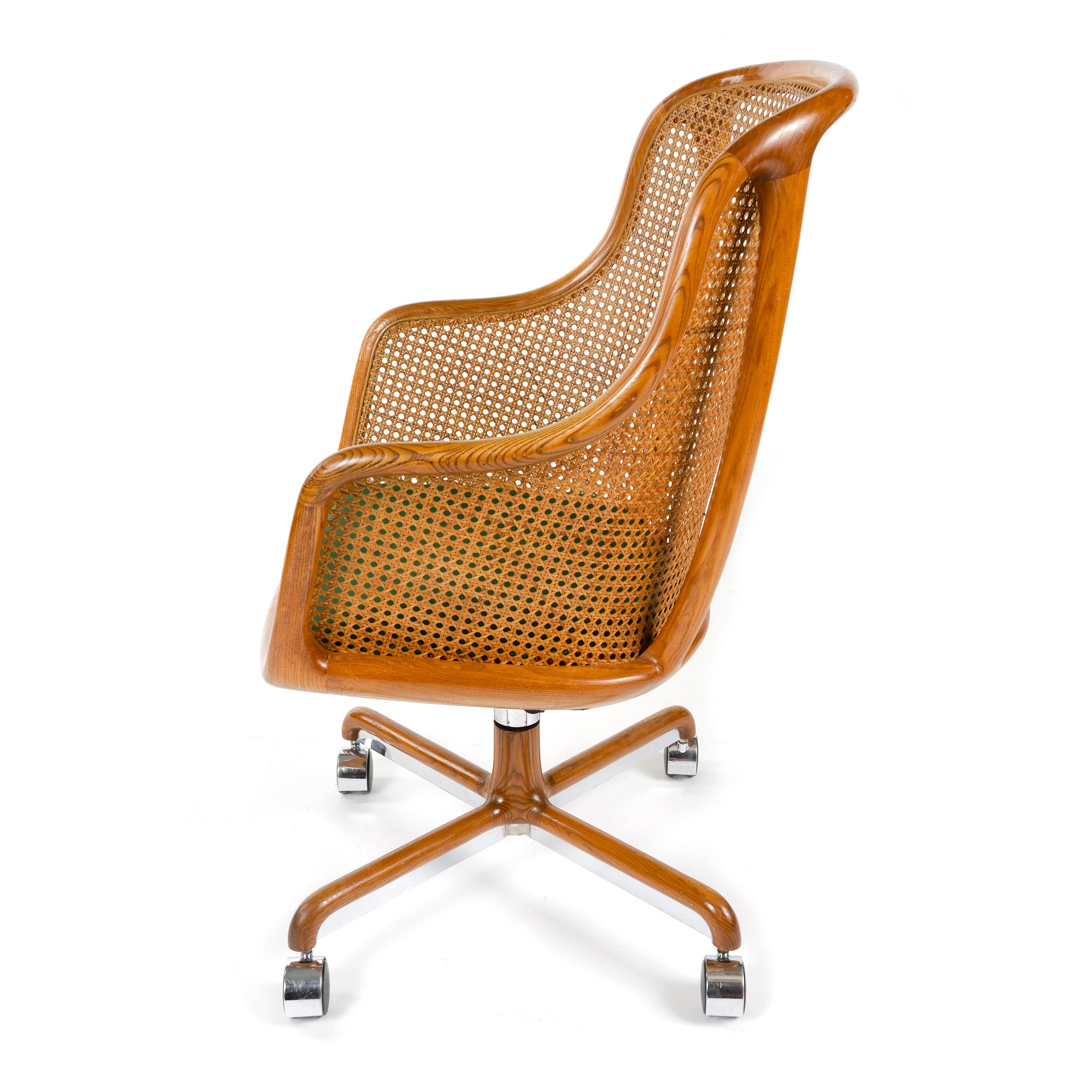 A highback desk chair with ash wood frame with caned back and arm, upholstered seat cushion on casters. Designed by Ward Bennett for Brickel Associates in the 1960s.
Please note: seat cushion might differ from image.