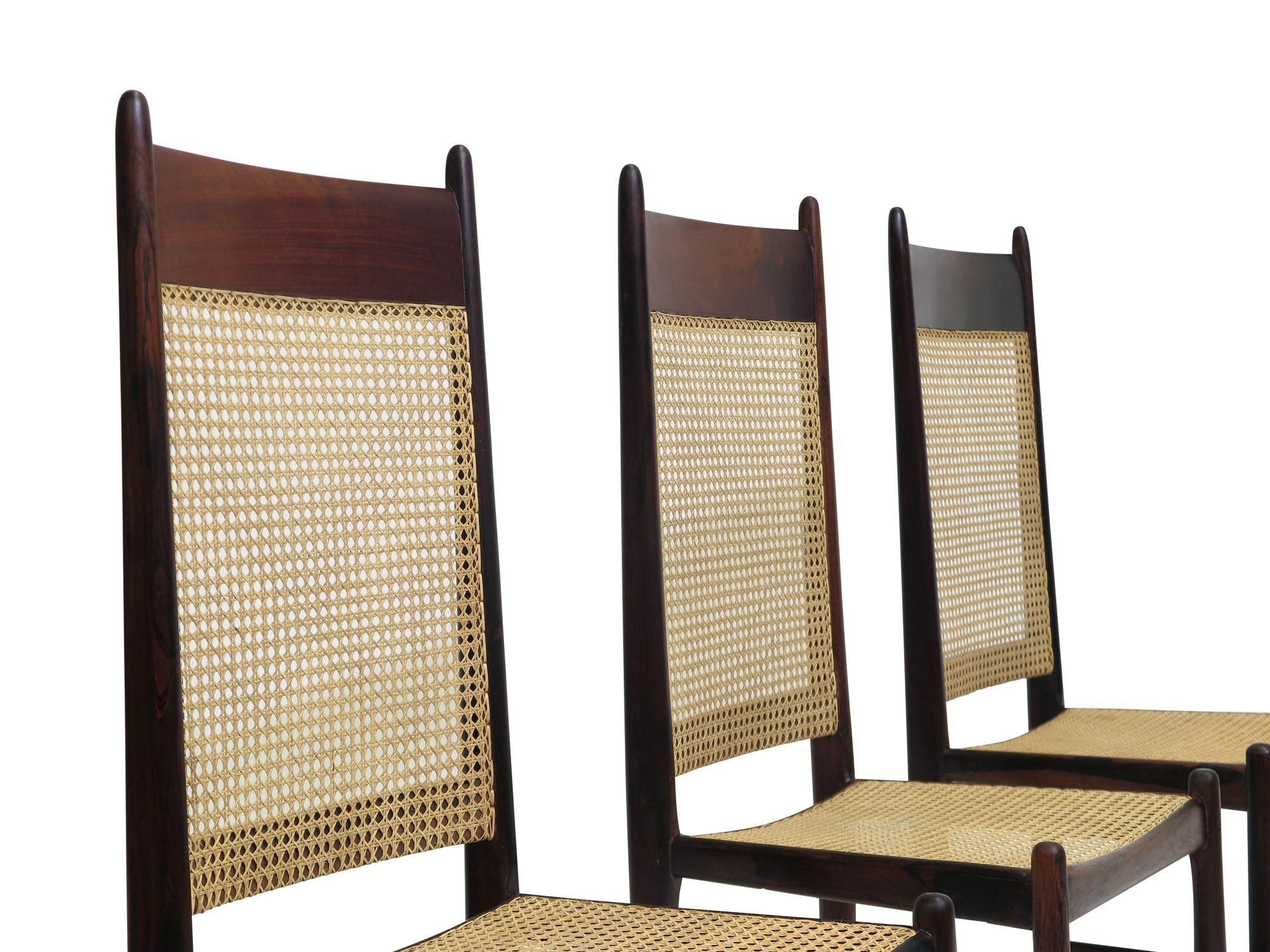 Midcentury Brazilian rosewood dining chairs attributed to Sergio Rodrigues, circa 1960 Brazil. Chairs are crafted of solid Brazilian rosewood with handwoven cane backs and seats. The cane has been rewoven and in excellent condition. Can be sold