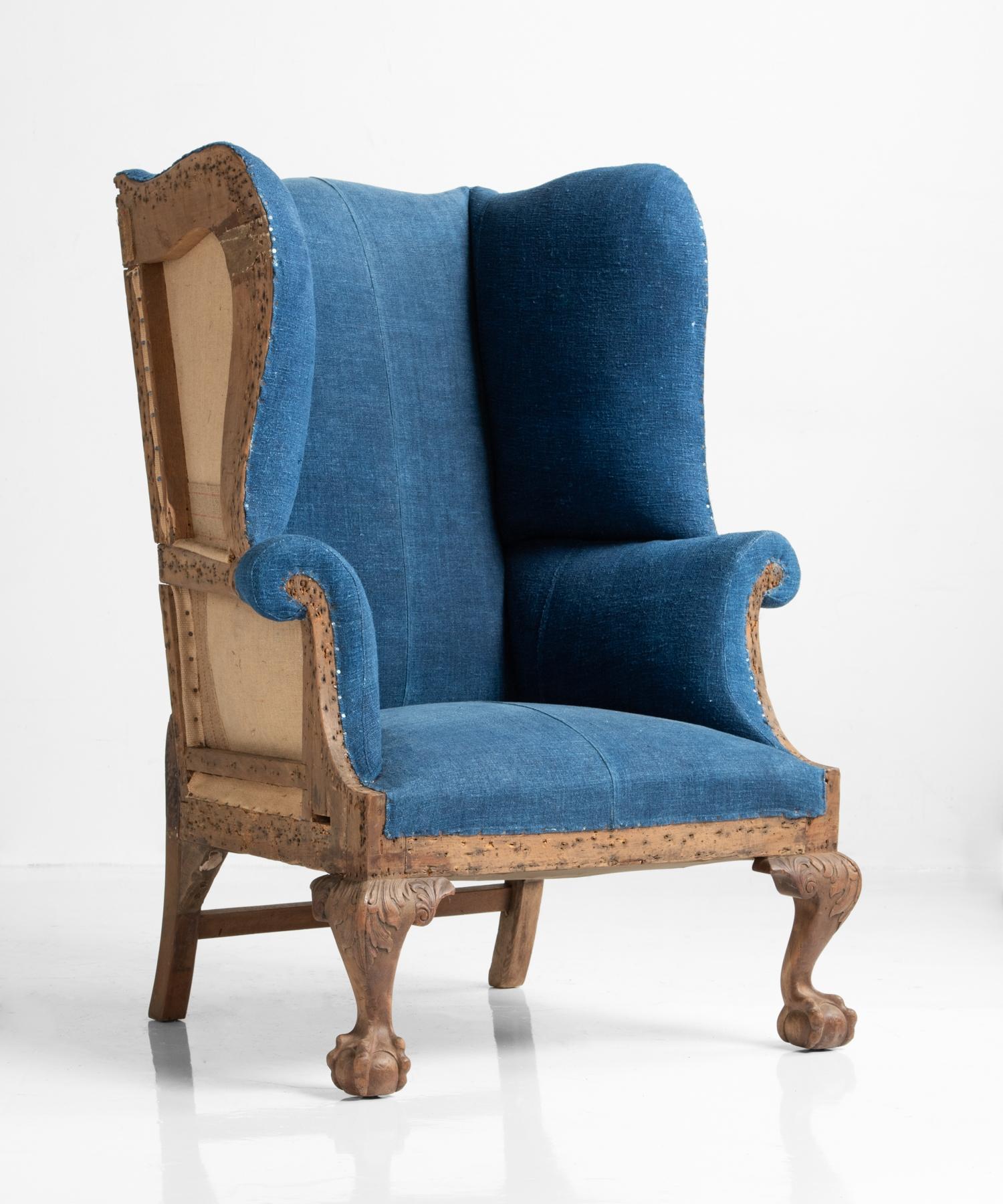 High back winged armchair, England, circa 1910.

Partially upholstered in a beautifully patinated indigo dyed fabric with exposed sides and back, as well as ball and claw front feet.