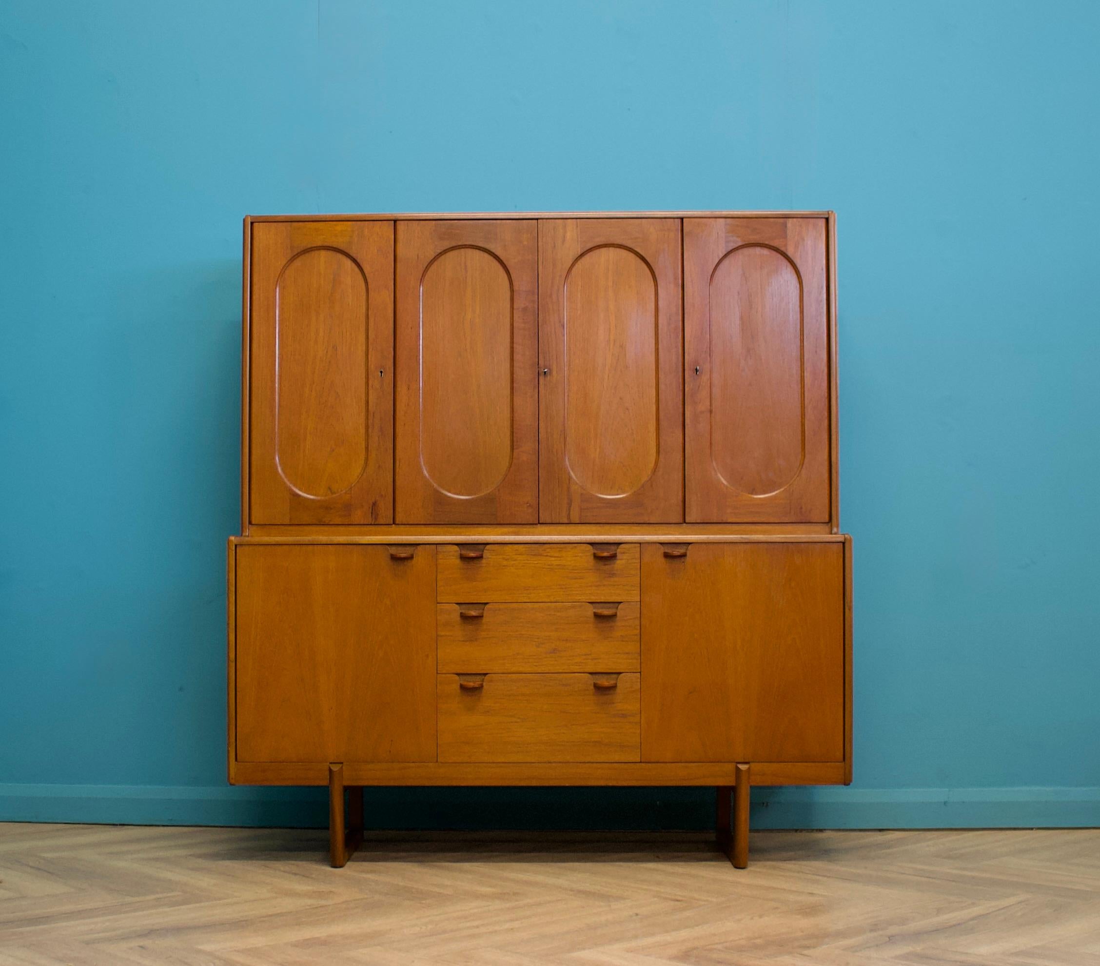 A highboard or drinks cabinet by Nathan in the Danish Modern style, circa 1960s.



This cabinet features five cupboards and three drawers. Each cupboard has a shelf, with the middle one containing two internal drawers.



Each handle is made of