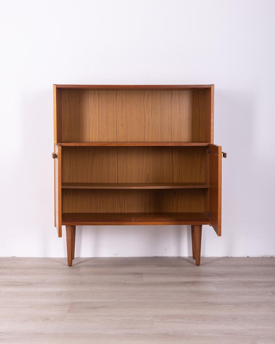 Highboard sideboard in teak wood, has two hinged doors with wooden and brass handles and a shelf at the top, Danish design, 1960s.

CONDITIONS: in good condition, it may show signs of wear given by time.

DIMENSIONS: height 102 cm; width 89 cm;