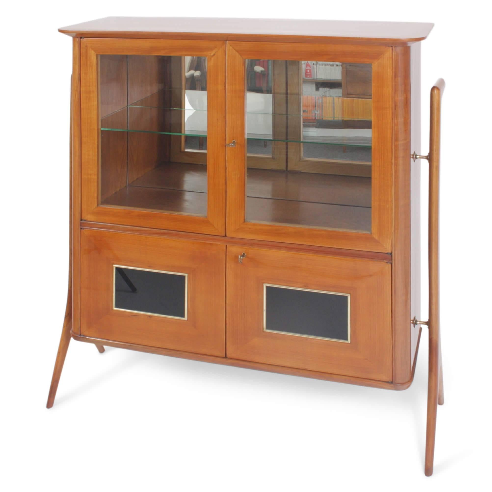 Italian Highboard out of cheerywood, on a forked stand with two glazed doors and two smaller doors, decorated with an ebonized square with brass framing. The rear wall of the display case is mirrored.