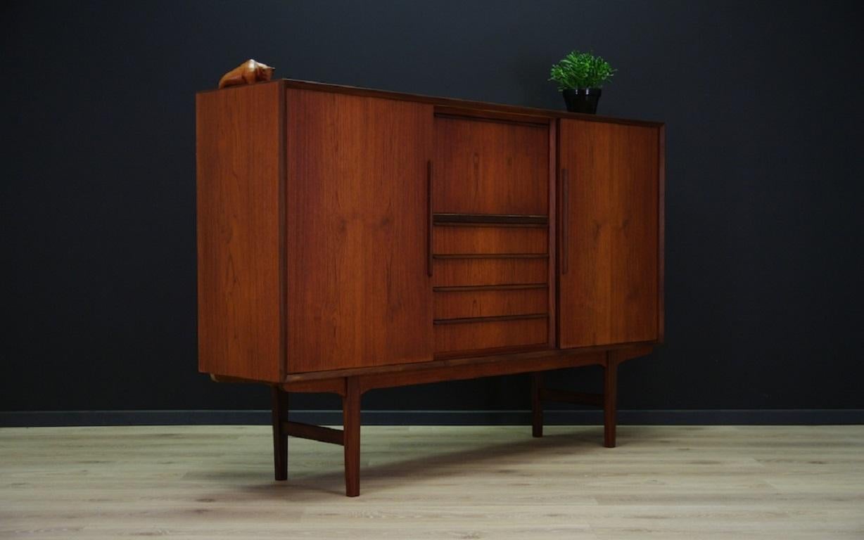 Original highboard from the 1960s-1970s. Beautiful straight, Scandinavian design with teak veneer. Unique teak handles and legs. Spacious interior with boards behind the adjustable door. Four practical drawers and rosewood veneer bar. Highboard in