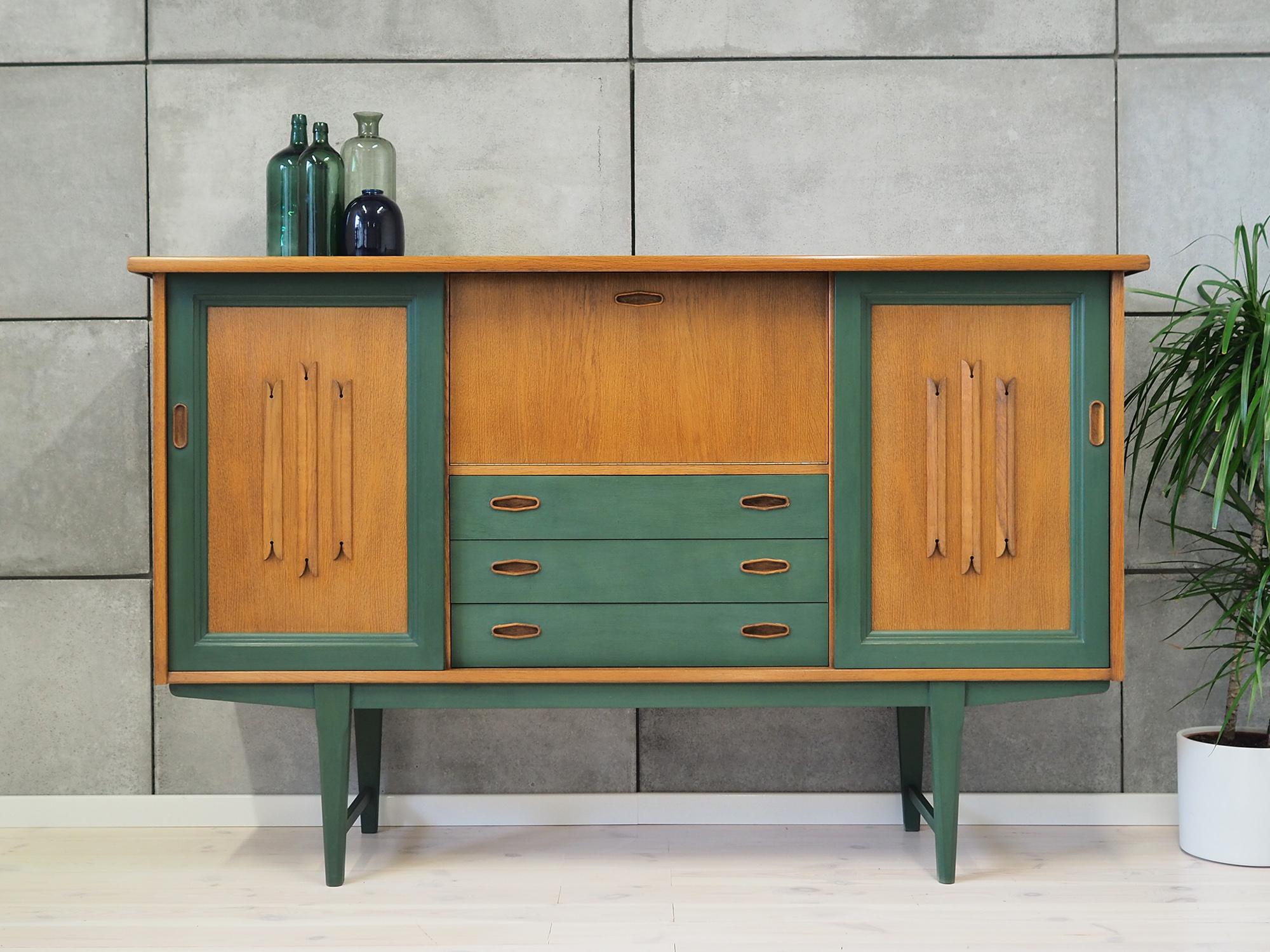 Highboard was made in the 1980s, Danish production.

Structure is covered with oak veneer. Legs made of solid wood painted green. Surface is finished with a shabby chic method. Inside the space has been filled with practical shelves. Inside there