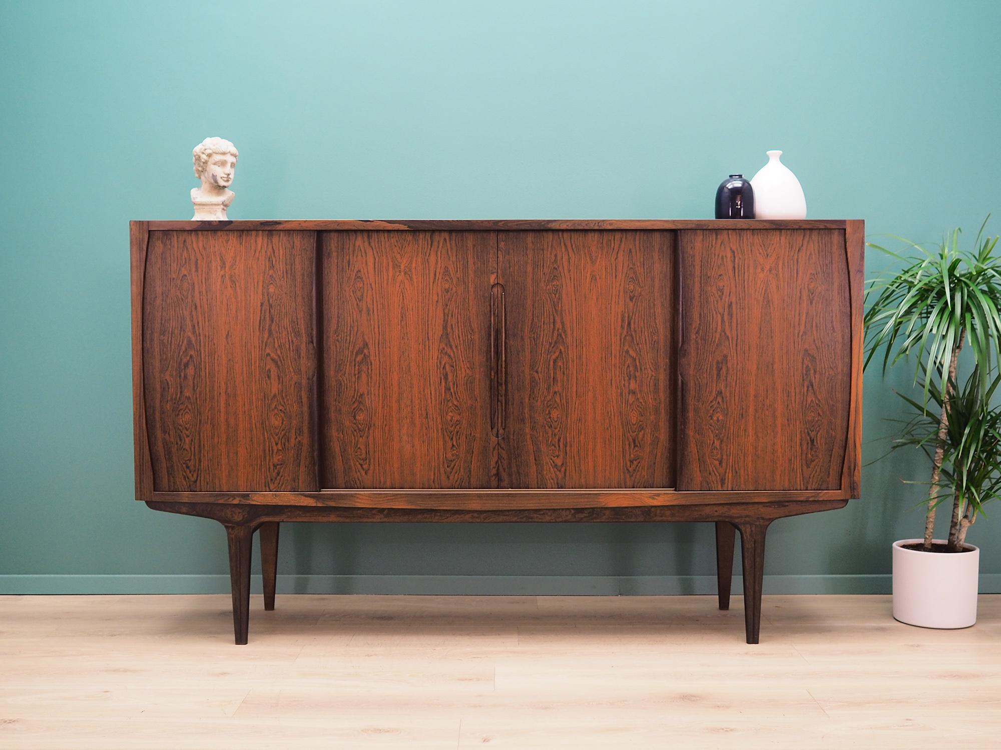 Highboard was made in the 1970s, Danish production.

The structure is covered with rosewood veneer. The legs and handles are made of solid rosewood. The surface after refreshing. Inside the space has been filled with practical shelves with height
