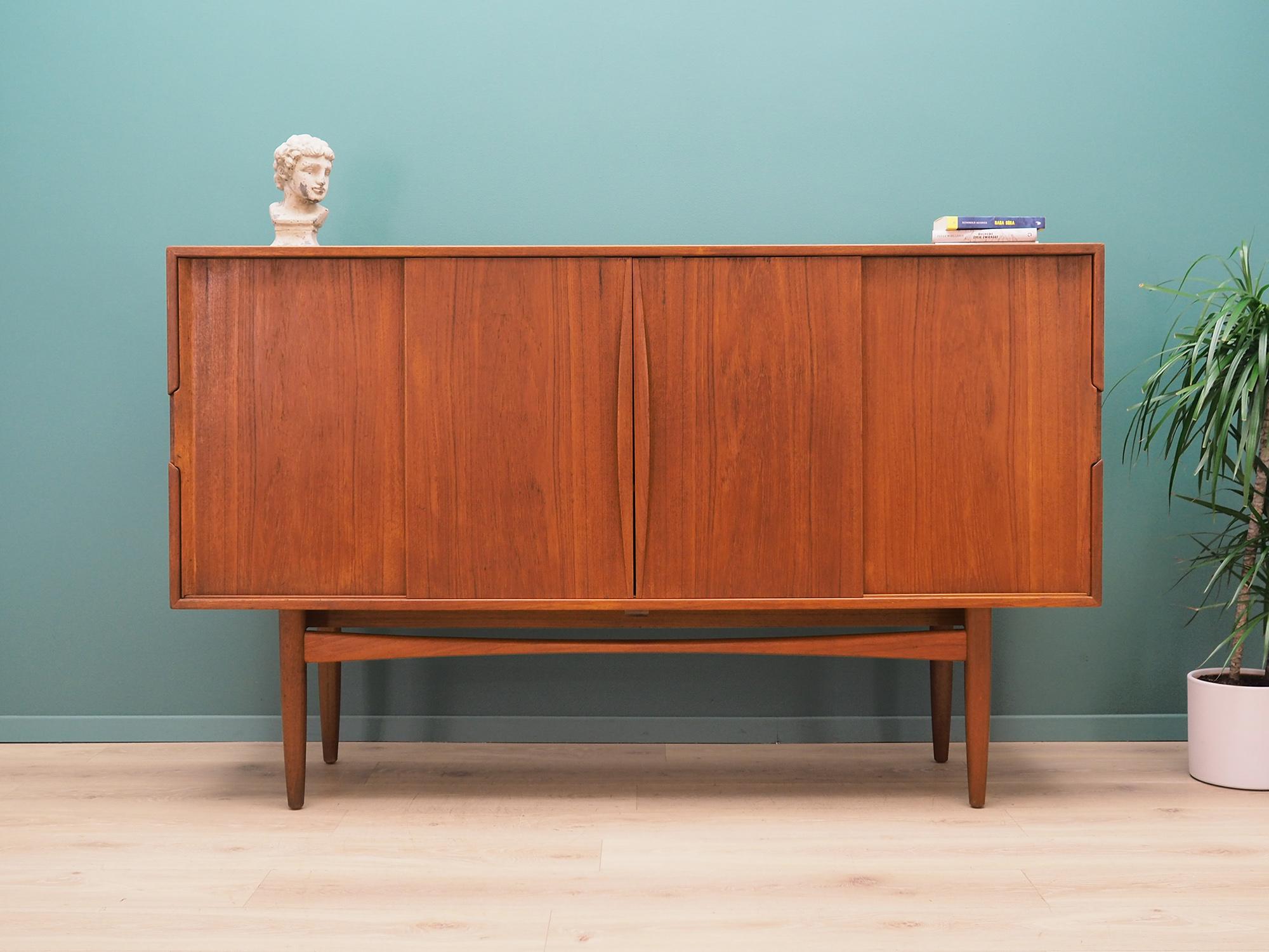 Highboard was made in the 1960s, Danish production.

Structure is covered with teak veneer, legs and handles are made of solid teak wood. Surface after refreshing. Inside, the space has been filled with practical shelves and drawers, shelves with