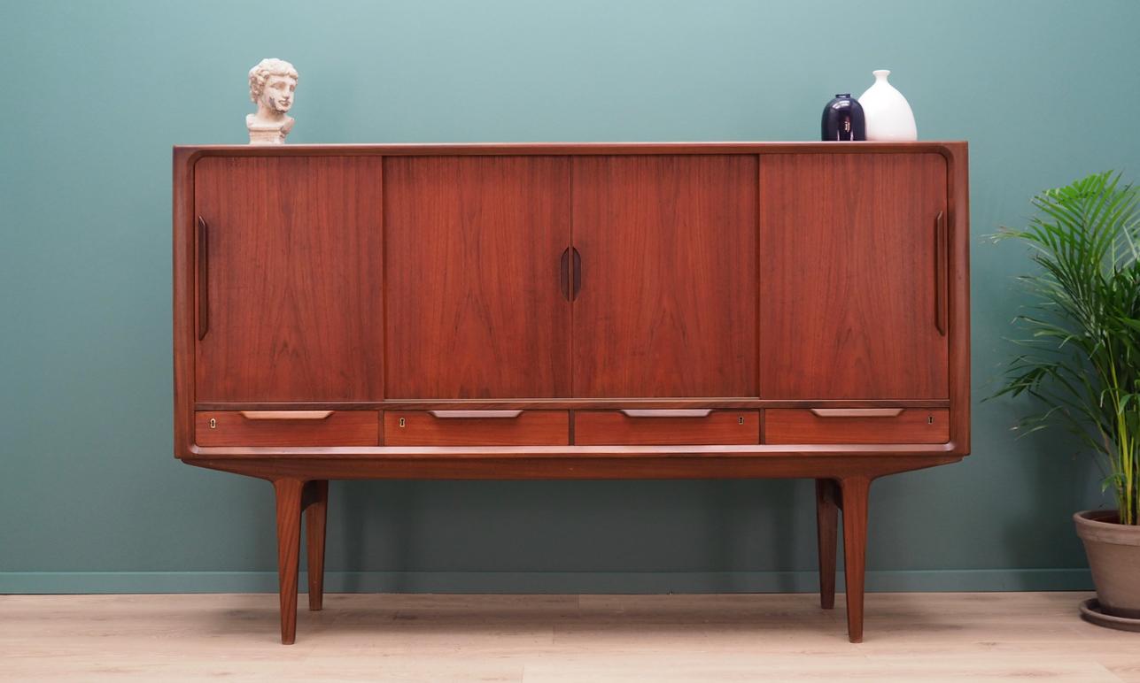 Phenomenal highboard from the 1960s-1970s. Danish design, Minimalist form. The surface of the furniture finished with teak veneer. Highboard has five shelves and two drawers behind sliding doors, four packing drawers. No key included. Maintained in
