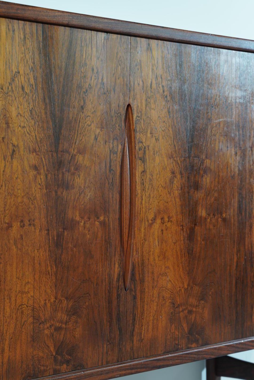 Mid-century highboard designed by Henning Kjaernulf for Bruno Hansen in the 60s. Sideboard with profiled edges and handles, giving the sideboard a light form. The High sideboard is made of rosewood, the interior of the highboard is made of solid