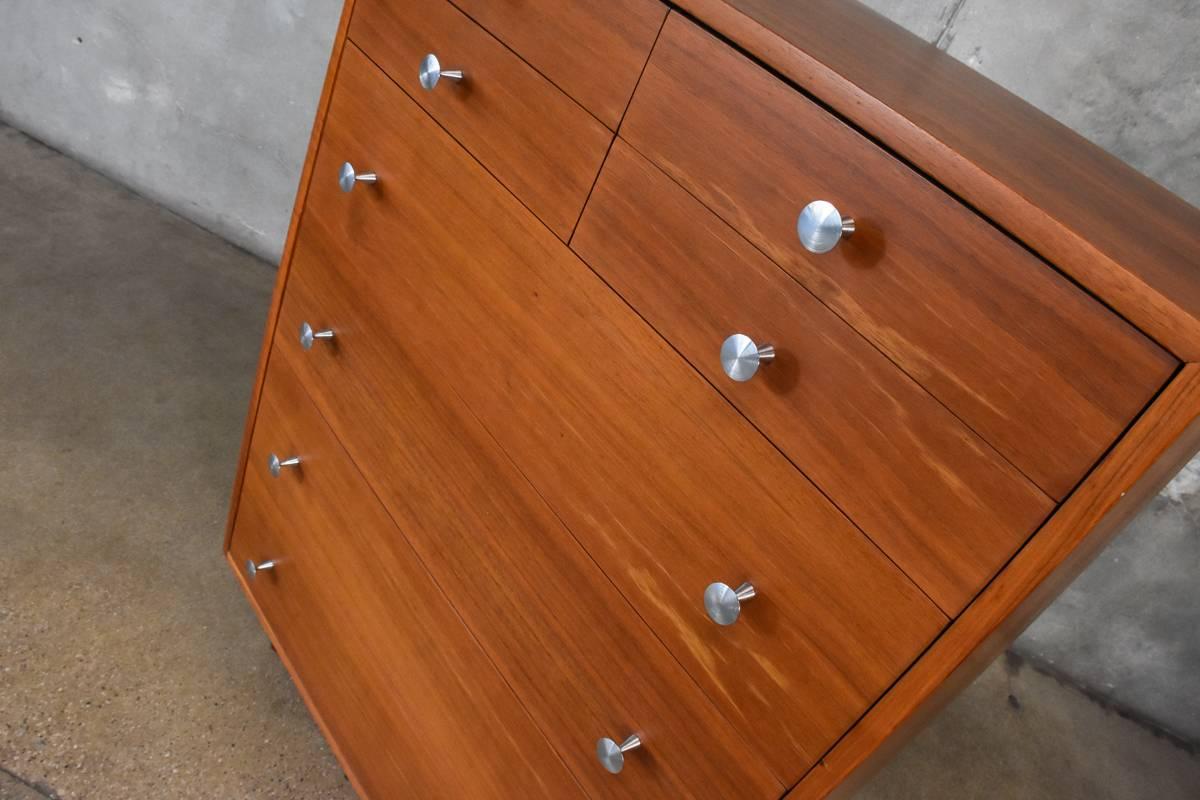 An uncommon highboy dresser designed by Glenn of California. With four large lower drawers and four small upper drawers this piece offers a ton of storage. The original pulls were missing and broken so they were replaced with reproduction from