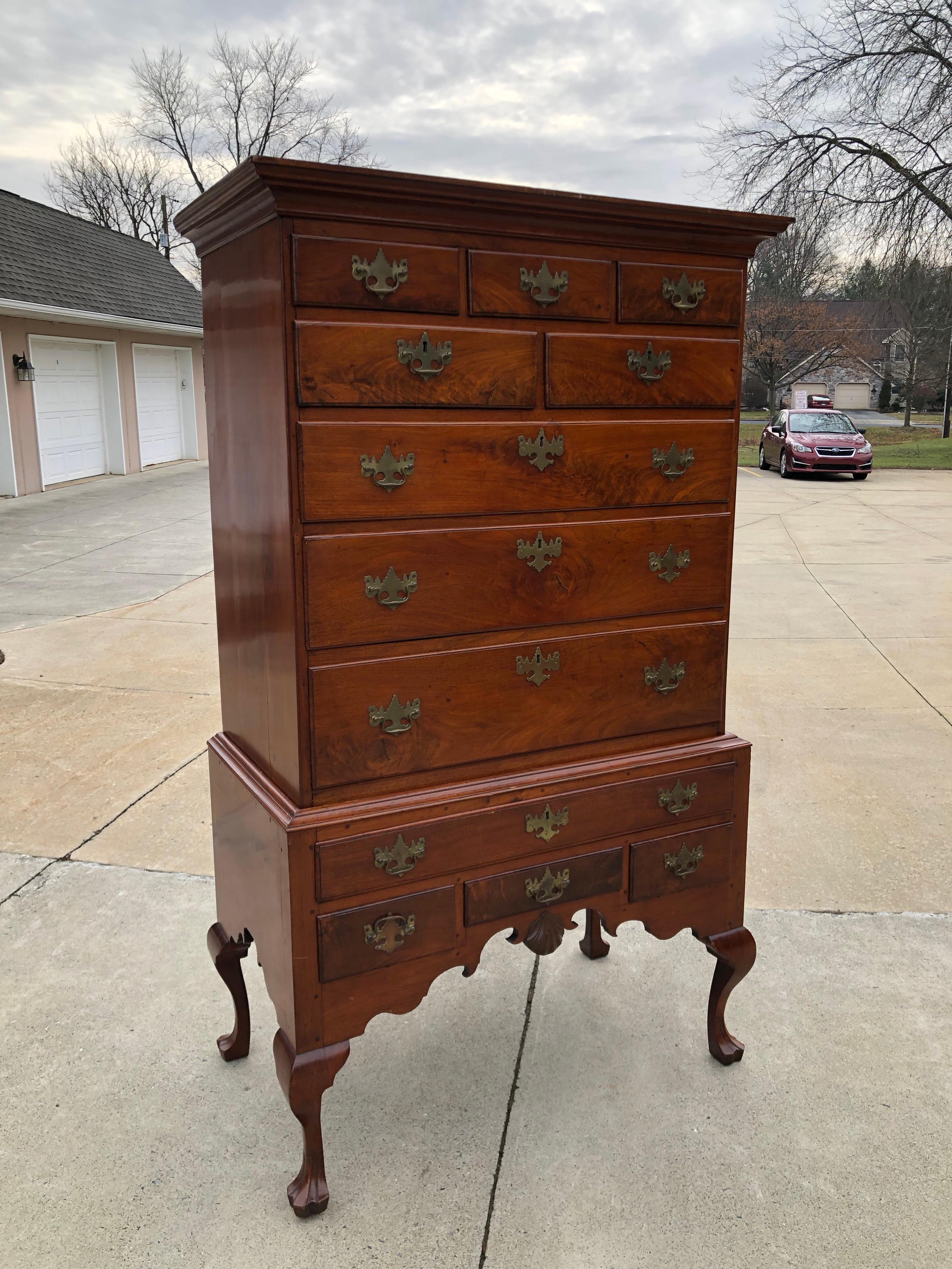 Highboy walnut Queen Ann carved shell Philadelphia, circa 1740.
Flat top with fine moldings on a case having cabriole legs ending in web feet. Shaped skirt centred with carved shell. Old but not original brass in original boring.
From the Bentecou