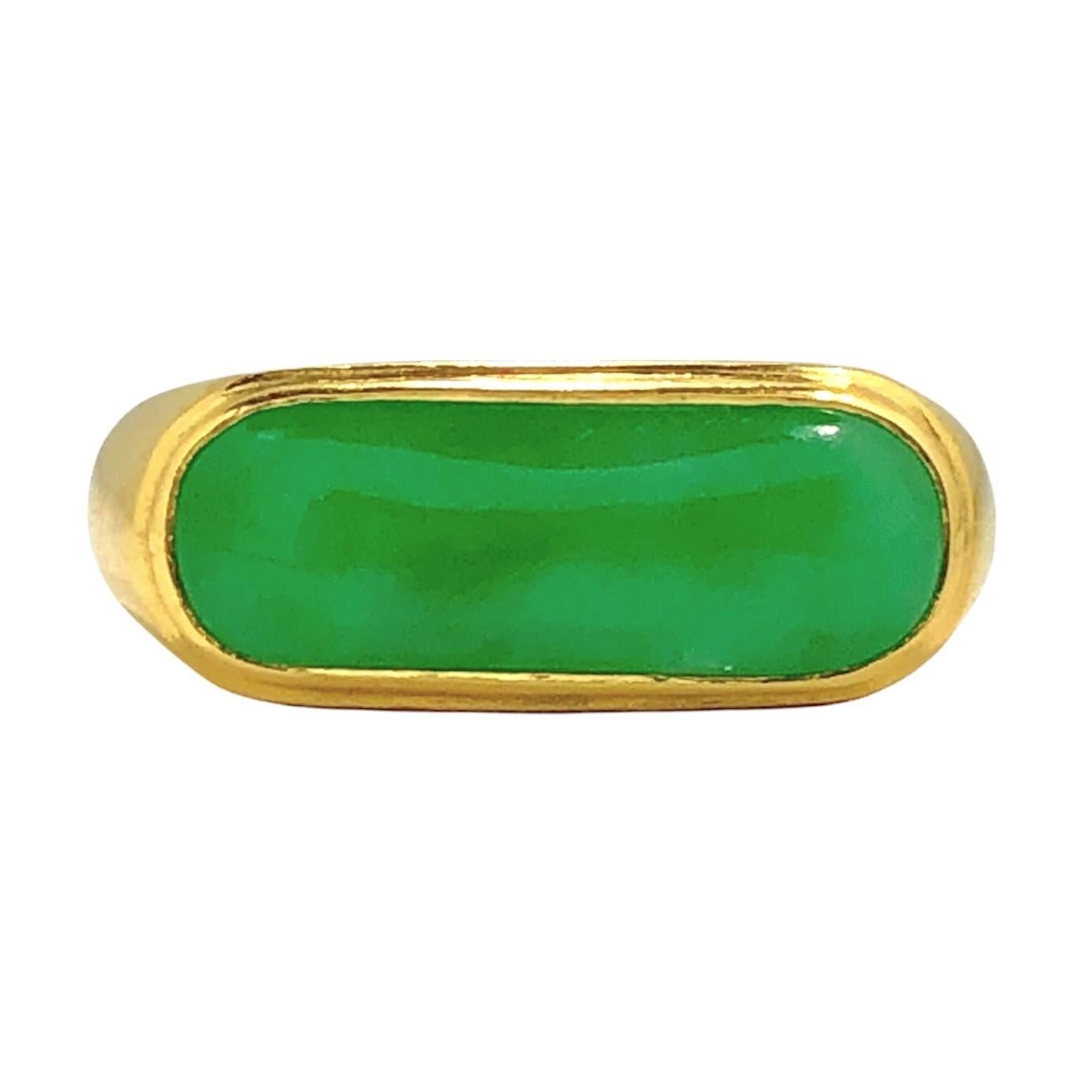 This wonderful vintage saddle ring is crafted from pure gold and hence, has a rich tone and luster not shared by many objects. At the center of it's design area is a vivid green Jadeite Jade cabochon measuring 3/4 inches by 1/4 inch and with intense
