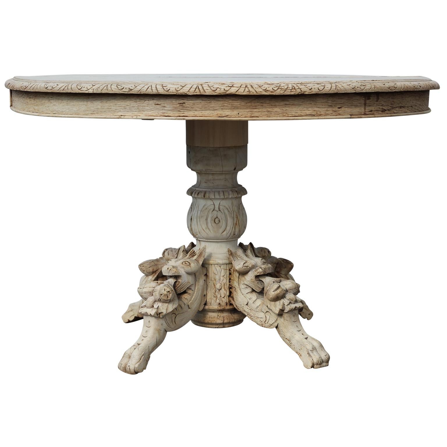 Highly carved bleached wood dining table that incorporates intricate animal motifs on each of the legs in the hunting style. The dining table is also carved with an attractive repeat pattern on the tabletop rim to add yet more visual interest.