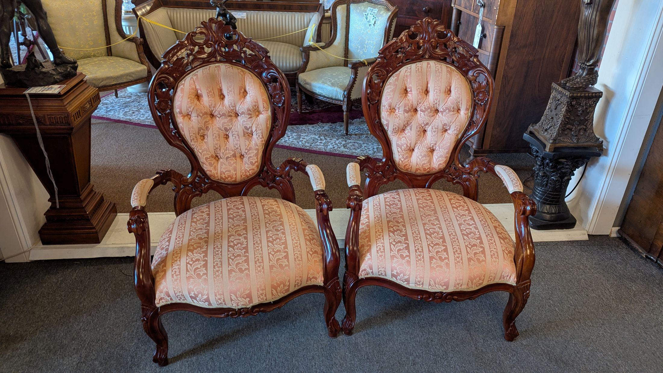 Highly carved and pierced mahogany parlor chair pair in the Victorian Belter style.  These are large sturdy and very comfortable chairs with no issues at all, upholstered with strap and high density foam, in a pleasant pink leaf stripe fabric with