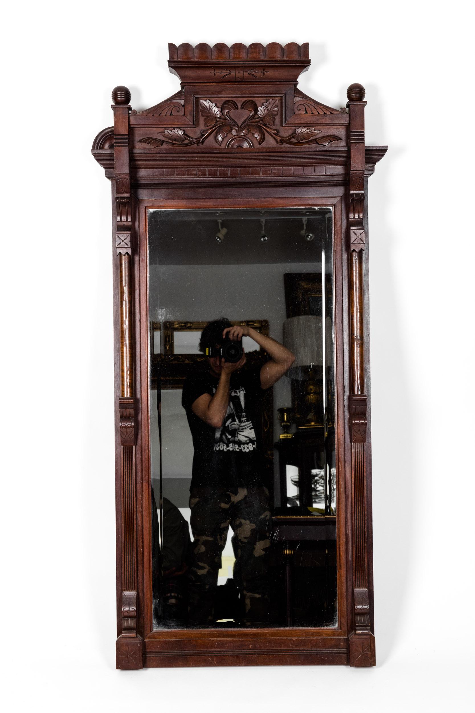 Highly carved Mahogany wood framed Victorian style rectangle hanging wall mirror with finely carved wood arch design top. The mirror is in excellent antique condition. Minor wear consistent with age or use. The mirror measure about 57 inches length