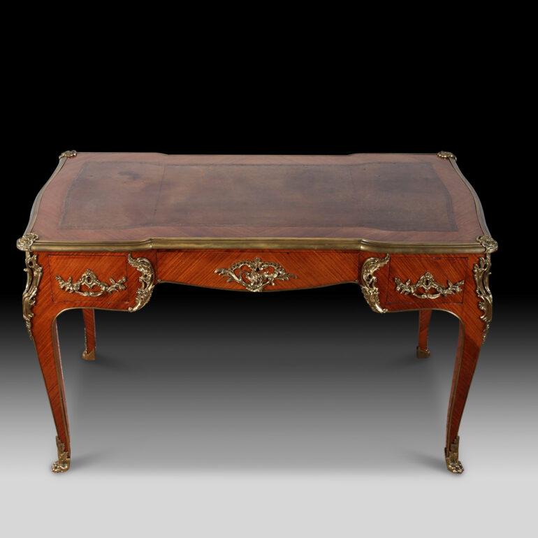 A fine small French Louis XV Rosewood writing table from the period of Napoleon III. The serpentine-shaped top with leather inset writing surface, above three frieze drawers and three matching simulated ones at the rear, on cabriole legs headed by