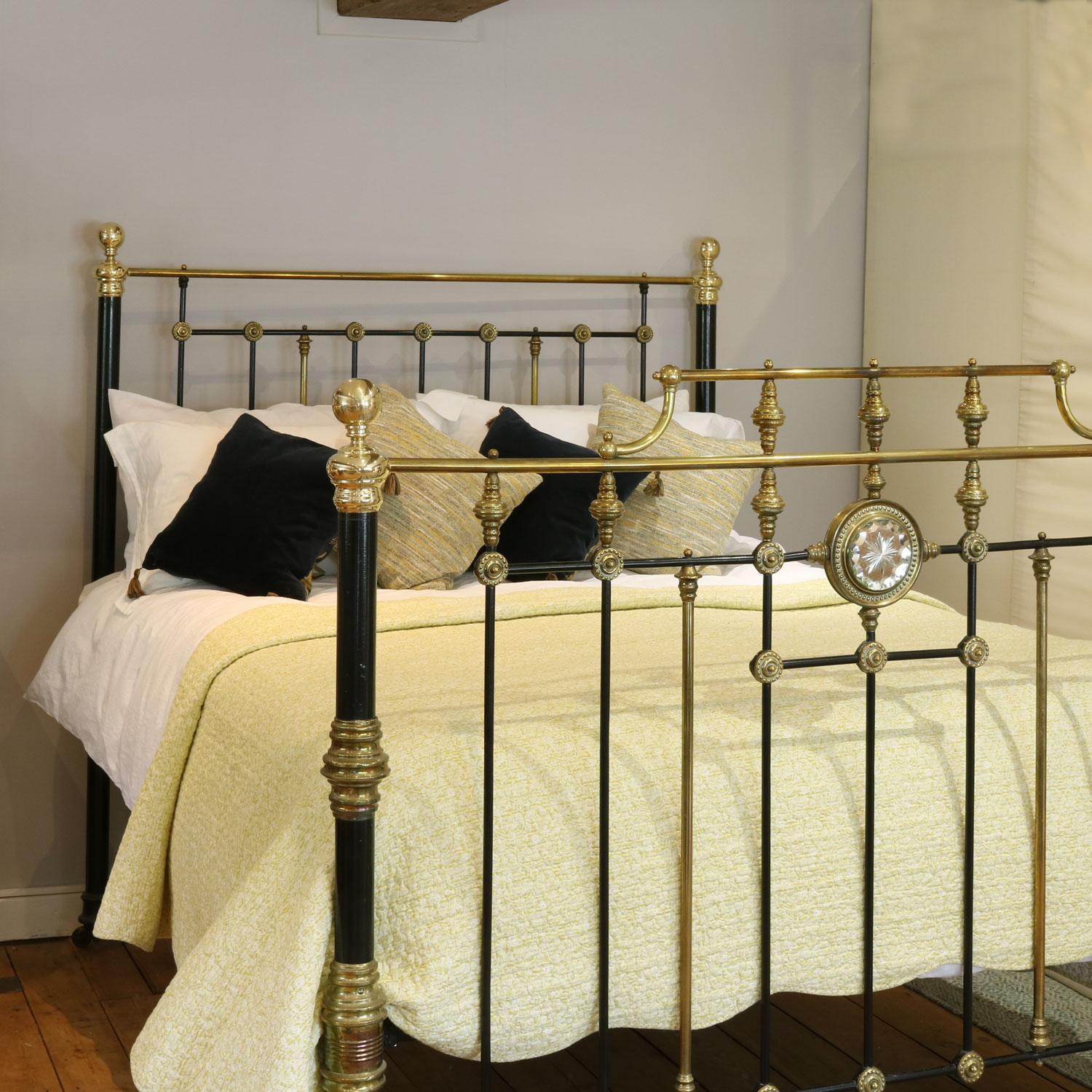 Splendid Victorian cast iron and brass bedstead in black with cut-glass mirror and a gallery in the foot panel. Highly decorative, with brass knee caps and side drops.

This bed accepts a UK king size or US queen size (5ft, 60in or 150cm wide) base