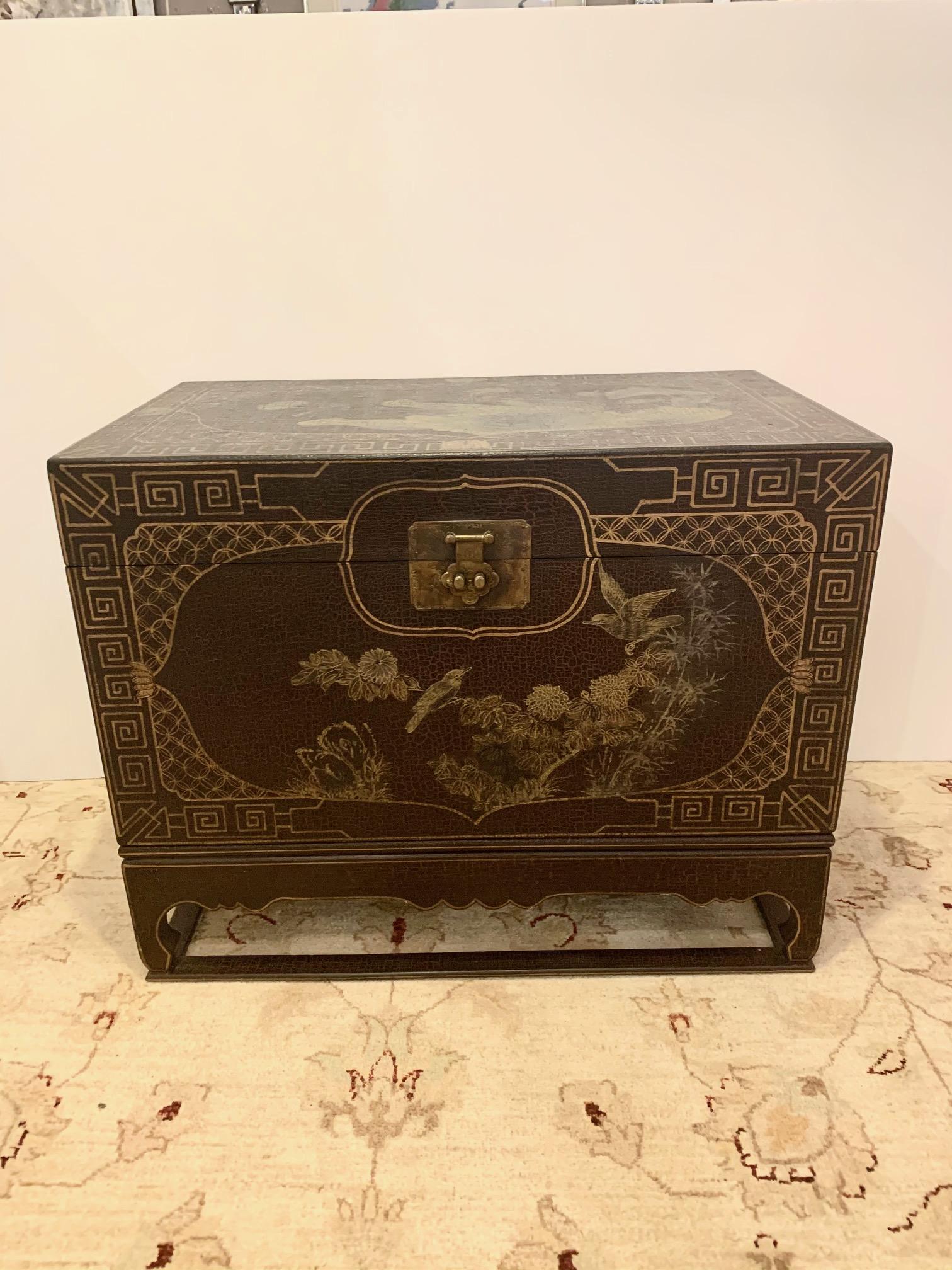 Black and gold chinoiserie style painted trunk on stand having marvelous Greek key design, birds and foliage with handsome brass hardware.
   