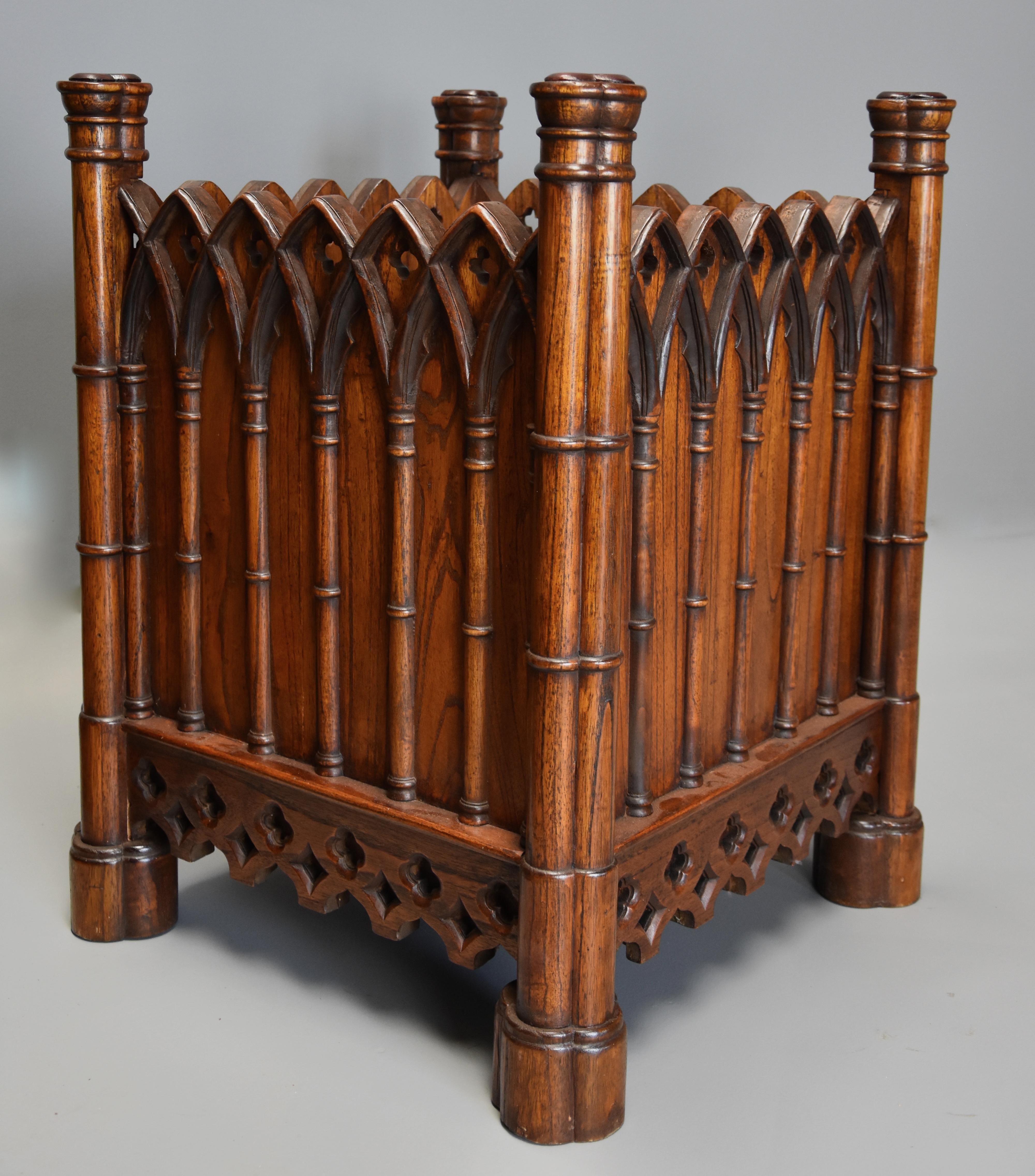 A highly decorative elm Gothic style planter.

This planter consists of four Gothic style corner supports with trefoil decoration to the top with Gothic style arched gallery with pierced quatrefoil design. 
 
This leads down to a frieze below