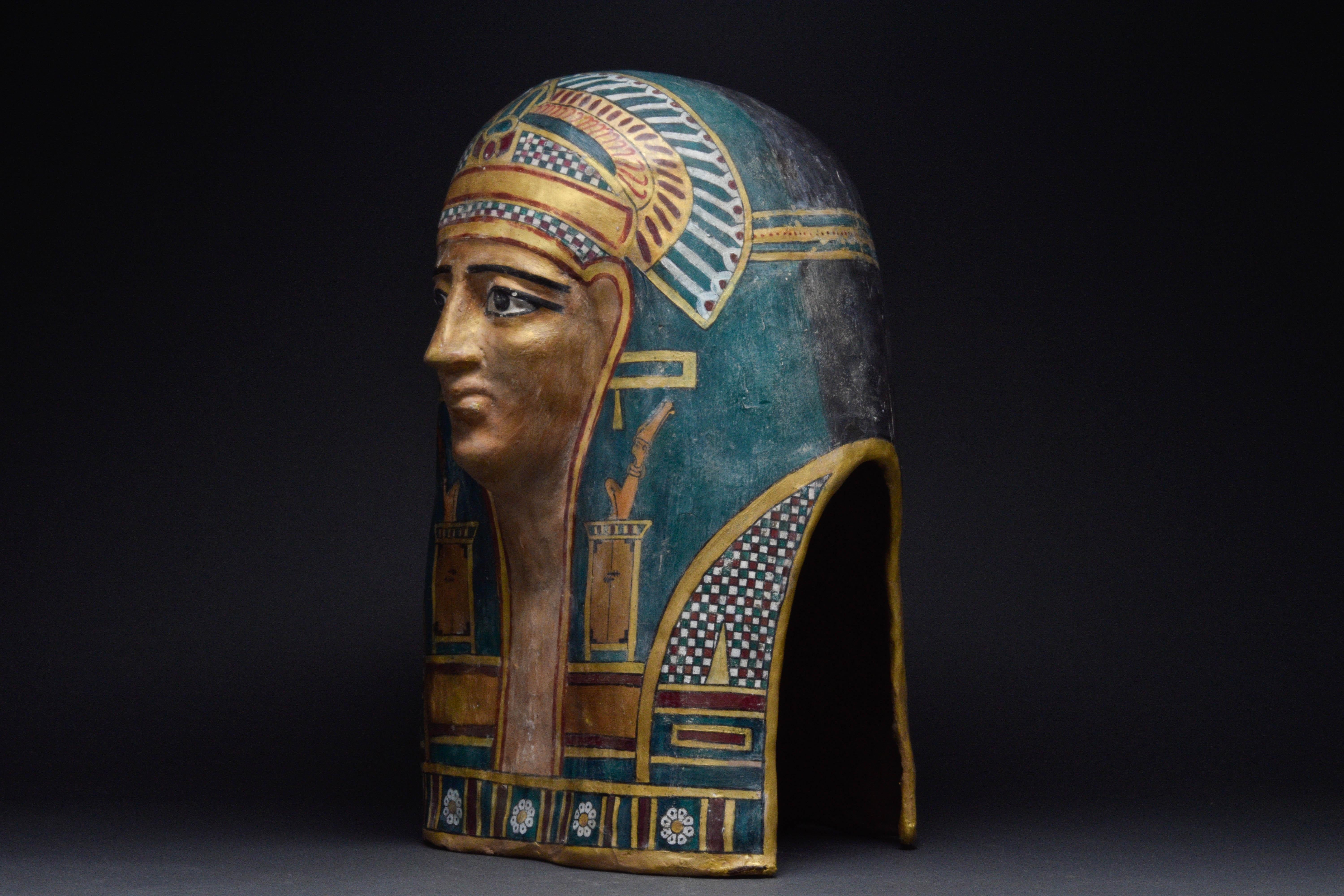 Ca. 332-30 BC. 

Highly Decorative, large, Ptolemaic Period, Egyptian, Cartonnage Mask depicting a face wearing a tripartite wig, the lappets falling gently behind the ears to the level of the chest. These lappets, now painted a turquoise blue