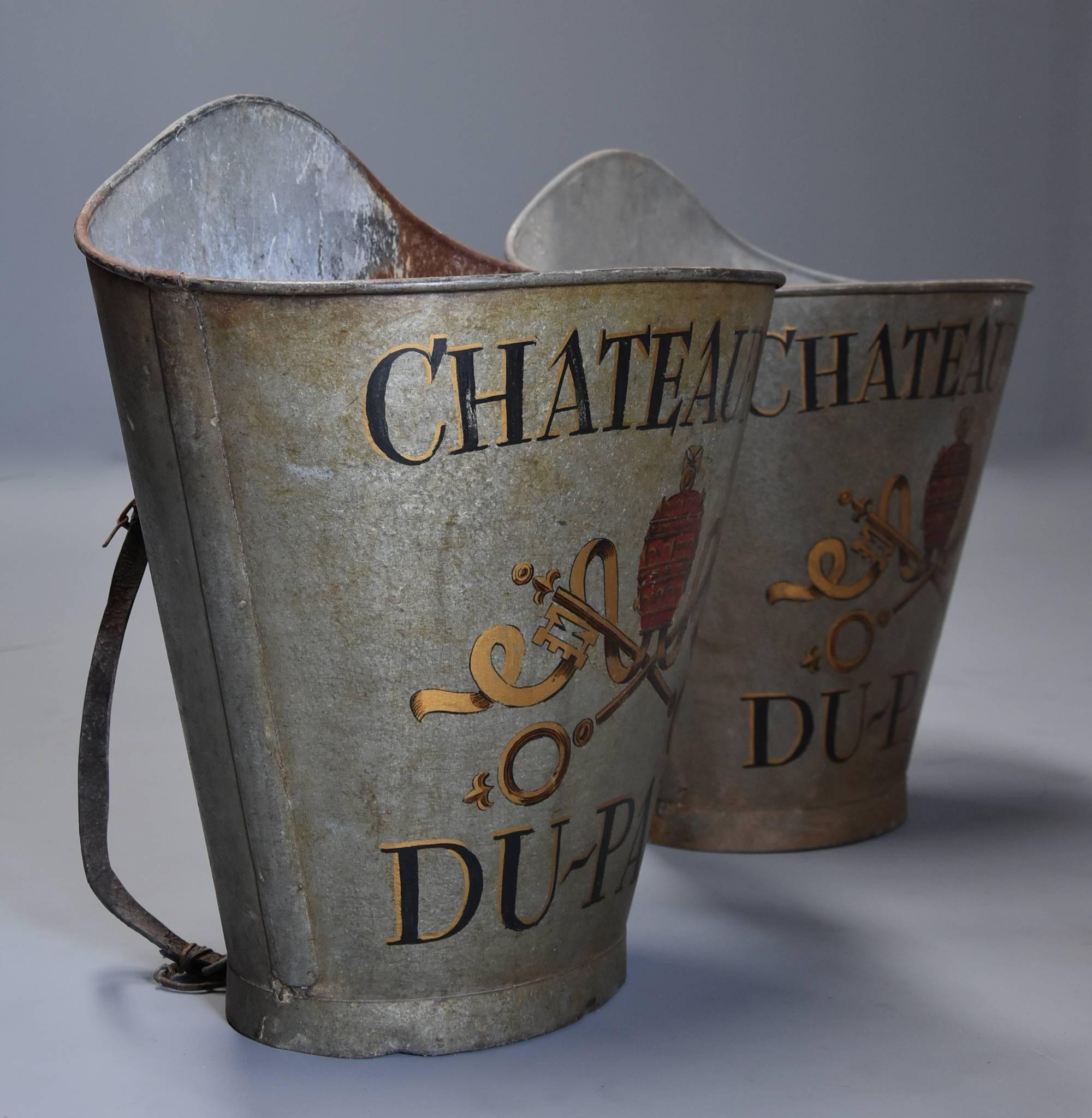 A highly decorative pair of galvanized metal grape carriers with painted decoration from the Chateaneuf-du-Pape wine region of France.

This pair of carriers are painted with original black, gold and red paintwork depicting the vineyard crest with