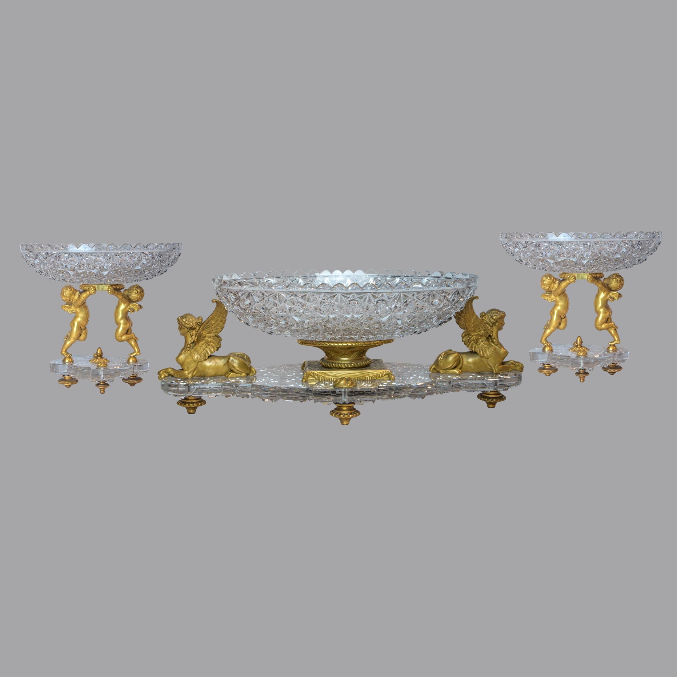 Highly important  French Ormolu and  Russian Cut-Crystal Three-piece Garniture by Baccarat Paris, late 19th century 
Comprising a center bowl flanked by sphinxes and a pair of tazze each supported by a pair of putti, stamped Baccarat  
Dimension: 19