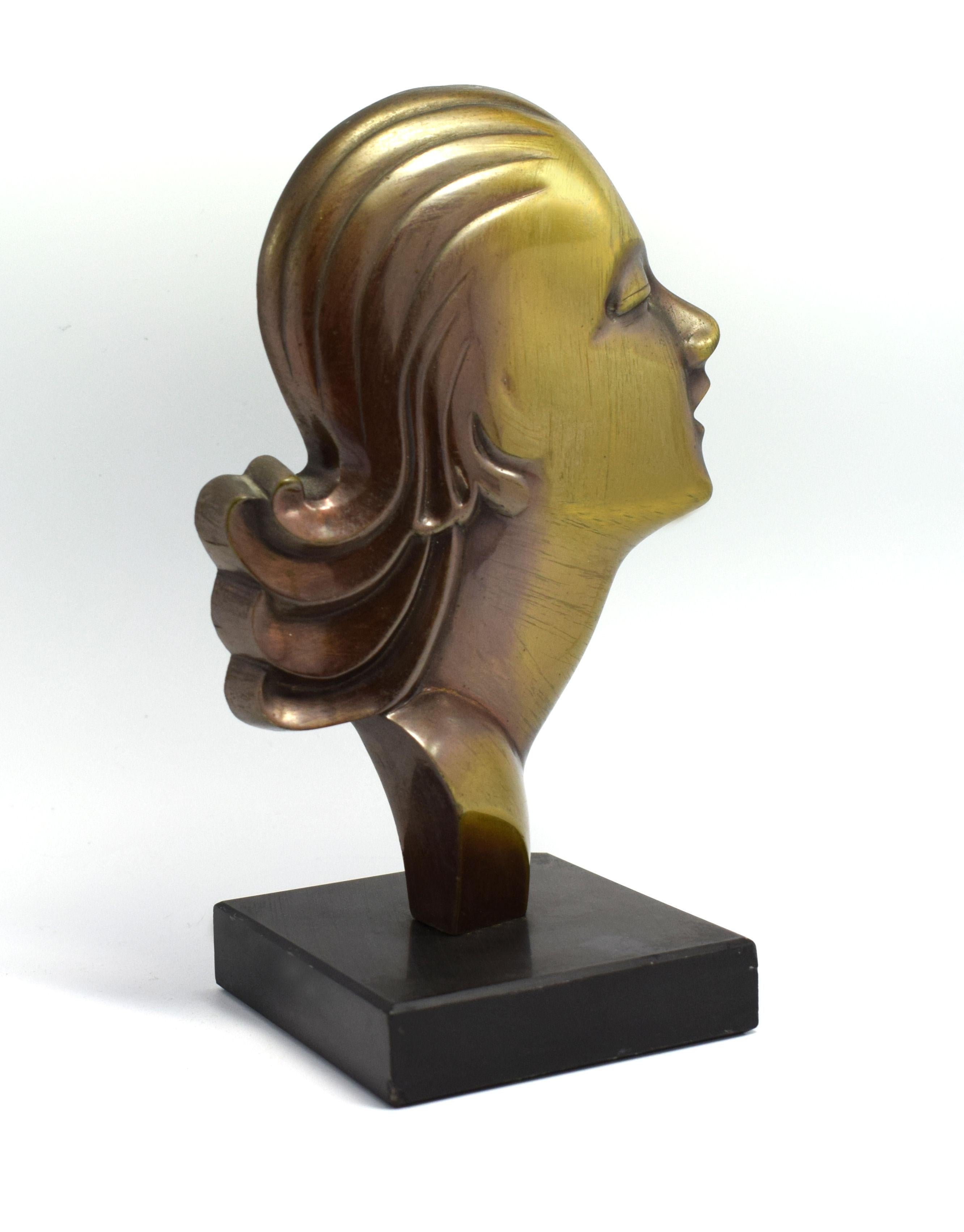 Sourced in Chateauroux, France, this is a solid brass profile of an Art Deco female surmounted on a black slate base. She dates to the 1930s and is in great condition and free from damage.
 