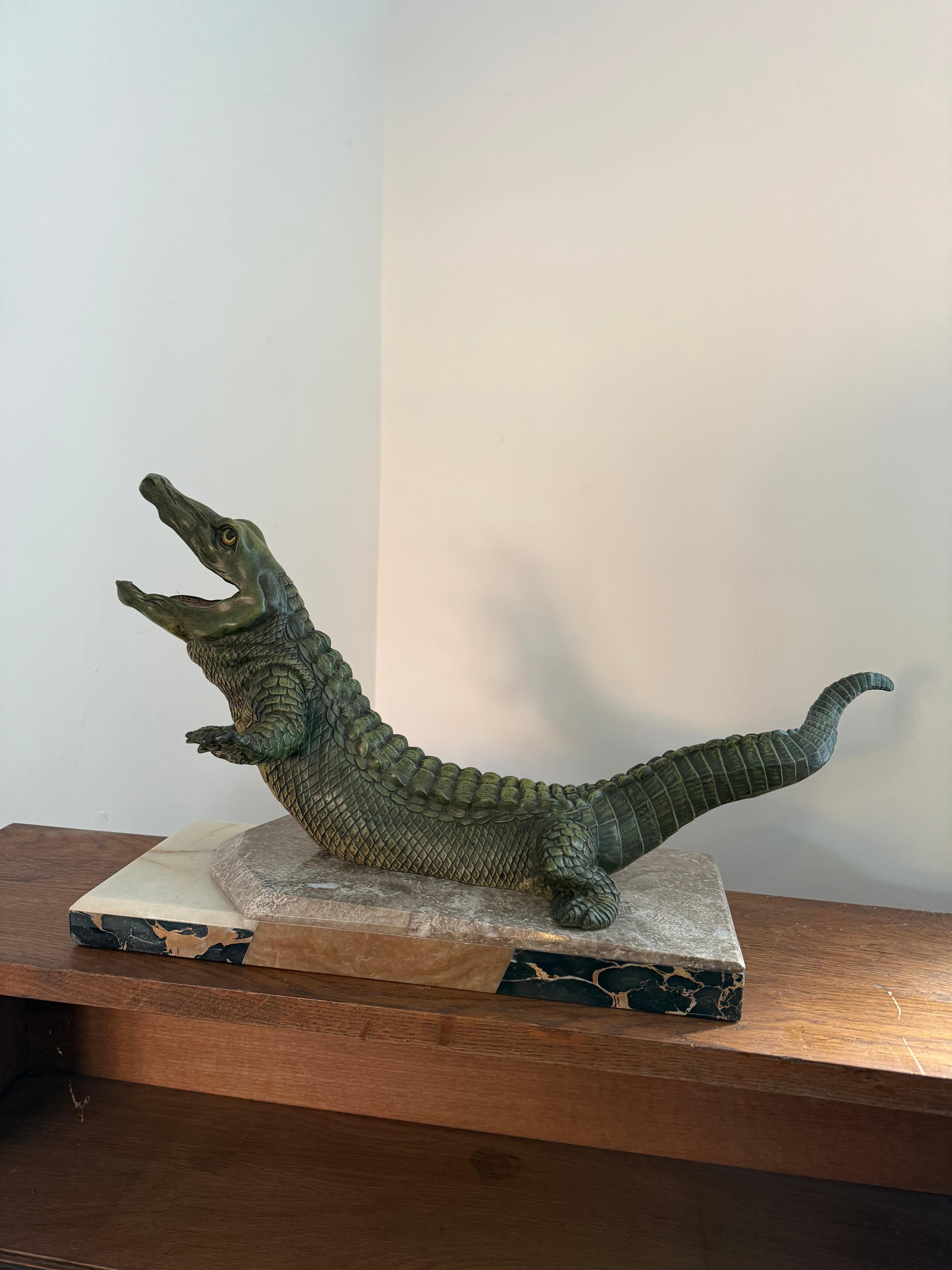Coccodrillo in spelta dipinto a freddo in stile Art Deco, montato su una base di marmo 

Francese, anni '30 circa 

12 pollici di altezza 

22 pollici di lunghezza 

7 pollici di profondità 