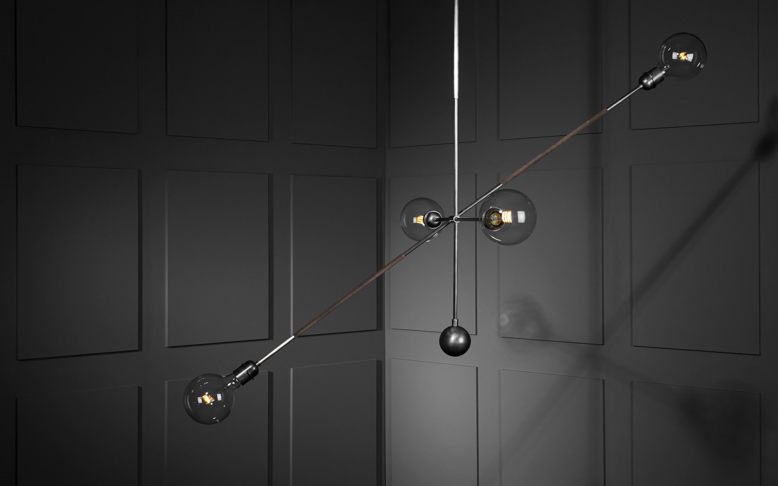 The Highwire pendant Light by APPARATUS STUDIO is inspired by the silhouette of famed French aerialist Philippe Petit on his wire against the Manhattan skyline. The “balance bar” is wrapped in leather or suede and can be tilted along its