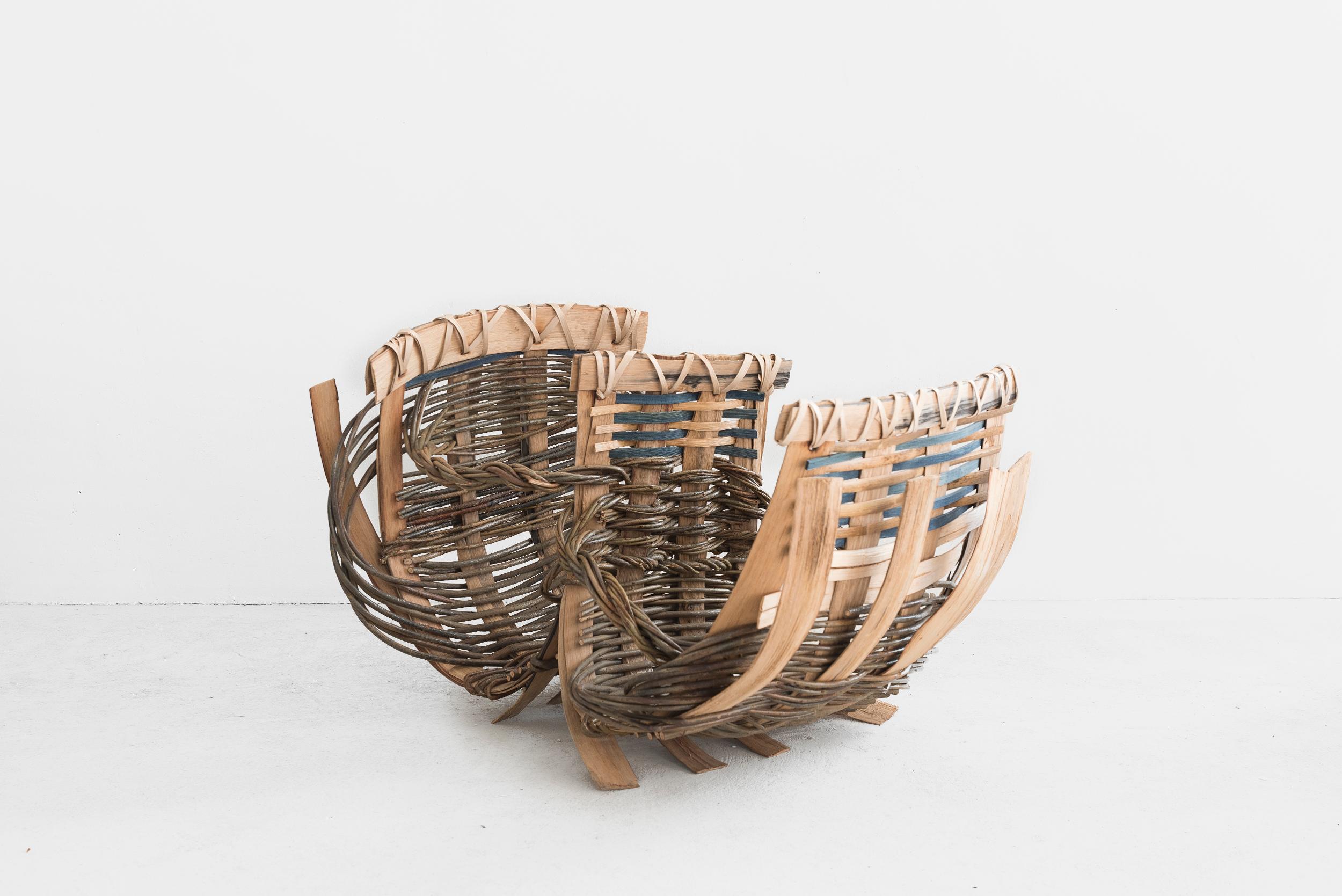 Hilary Burns 
Pair of baskets
Manufactured by Hillary Burns
Produced in exclusive for SIDE GALLERY
Devon (England), 2019
Catalan Carpace 

DOUBLE BASKET
Willow, split Cornish bamboo, cleft chestnut, pounded ash, indigo dye
Measurements: 80