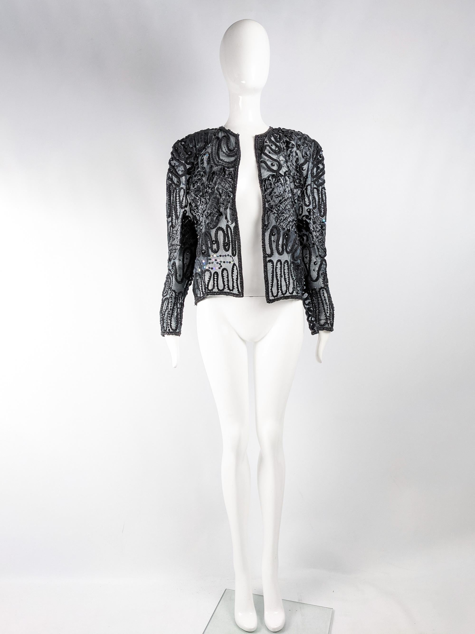 A beautiful vintage womens jacket from the 80s by Hilary Floyd. In a sheer black silk organza fabric with shoulder pads (that could be easily cut out), an open front, sequins and ribbon work. Perfect for a party. 

Size: Marked UK 10 / US 8 / EU