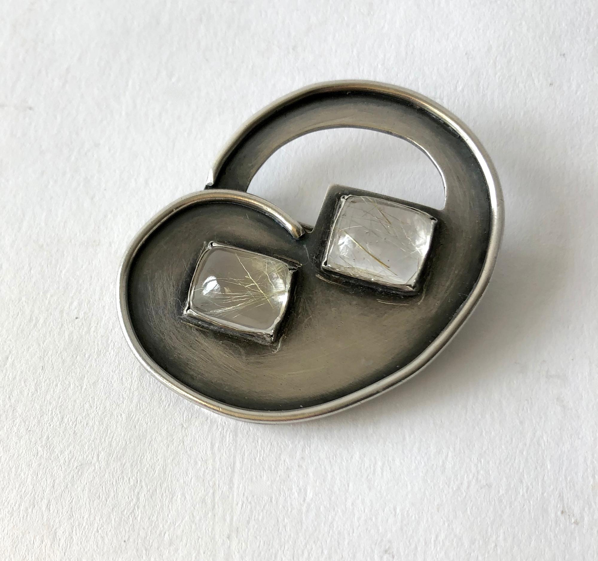 Modernist sterling silver and rutilated quartz brooch created by enamelist and jeweler, Hilda Kraus.  Brooch measures 1 3/4