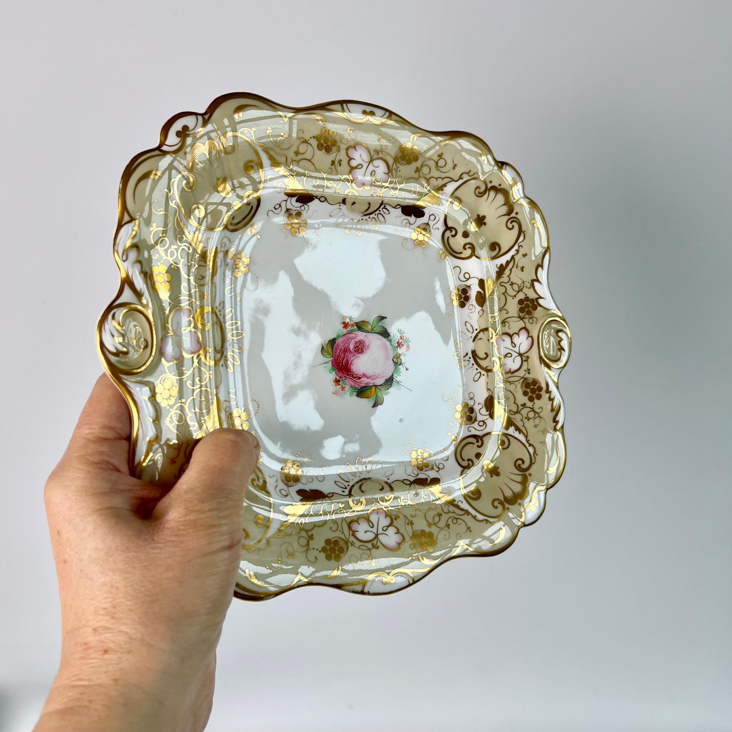 This is a beautiful cake plate from about 1830, made by Hilditch. The plate has warm beige ground with an elaborate gilt pattern, and a beautiful pink cabbage rose in the centre.

The Hilditch pottery only operated under the name Hilditch from 1811
