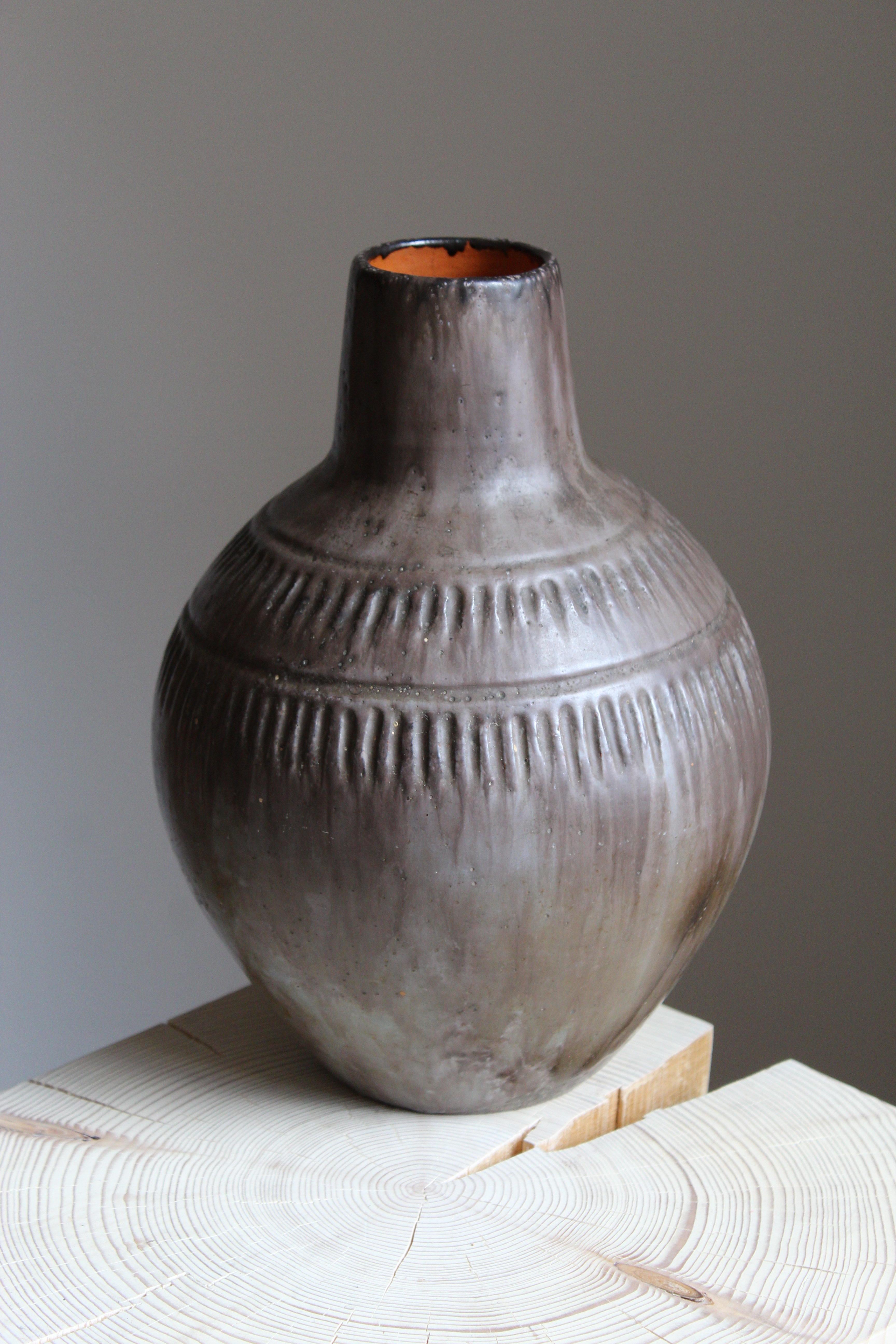 A sizable earthenware vase. Designed and produced by Hildur Haggård (1885- 1958). Painted earthenware featuring simple incised ornamentation.