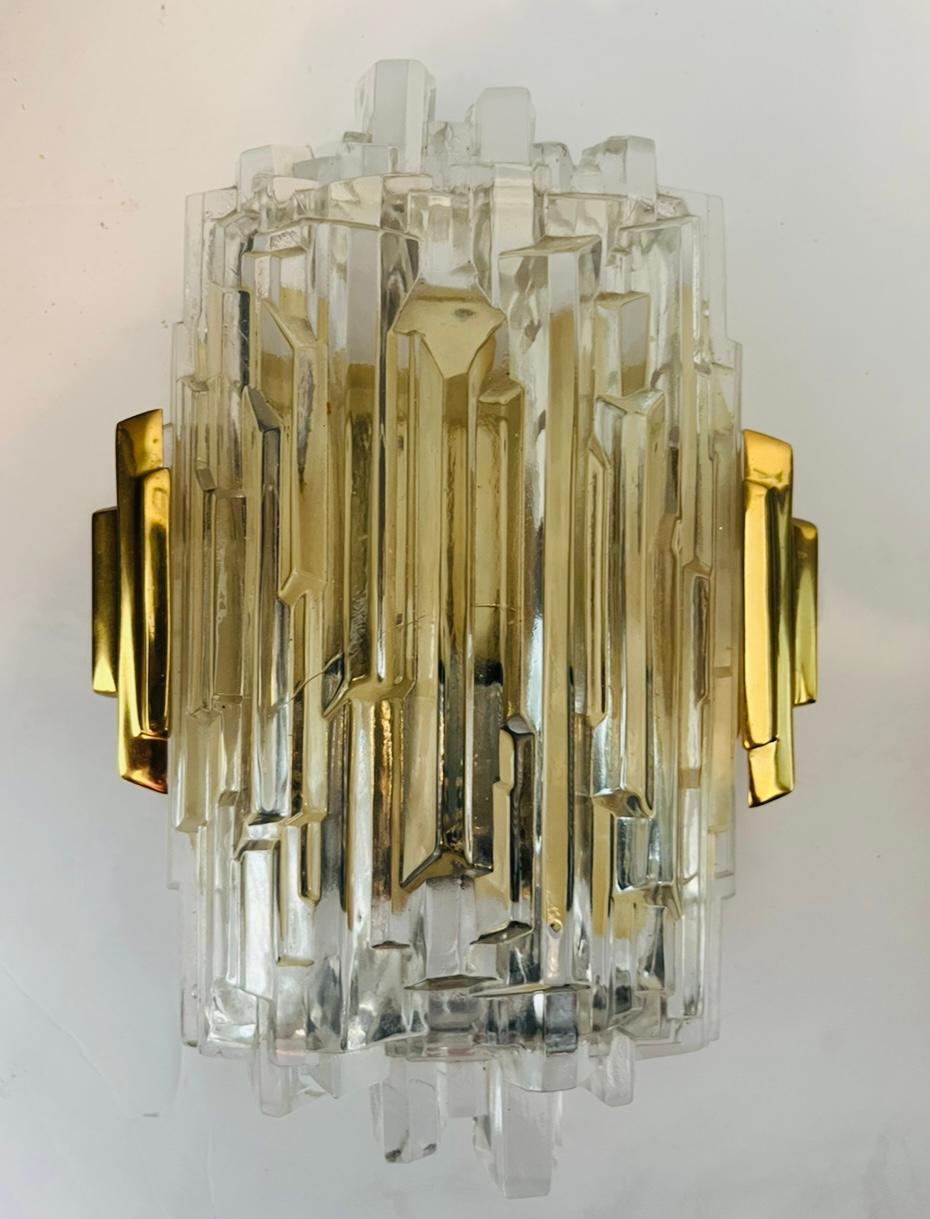 A beautiful German 1970s wall light with golden brass fittings and a heavy crystal shade cut into an ice pattern. One candelabra socket each. Made by the lighting company, Hillebrand. Rewired. 5 Available.