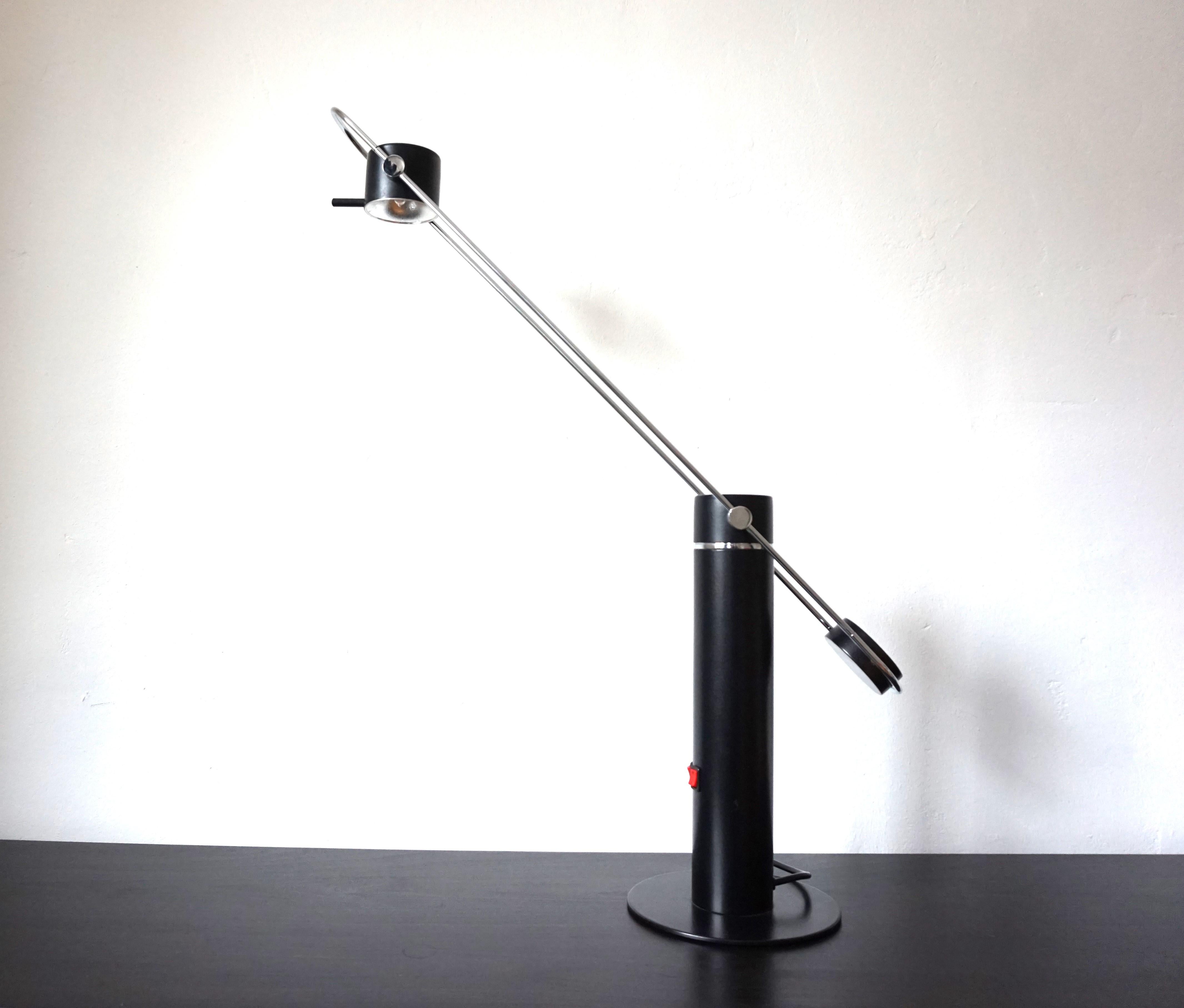 This delicately crafted table lamp with a swiveling arm is in excellent condition. The arm of the lamp made of stainless steel swivels as light as a feather and is also height-adjustable. The black round lamp head is infinitely adjustable and can be